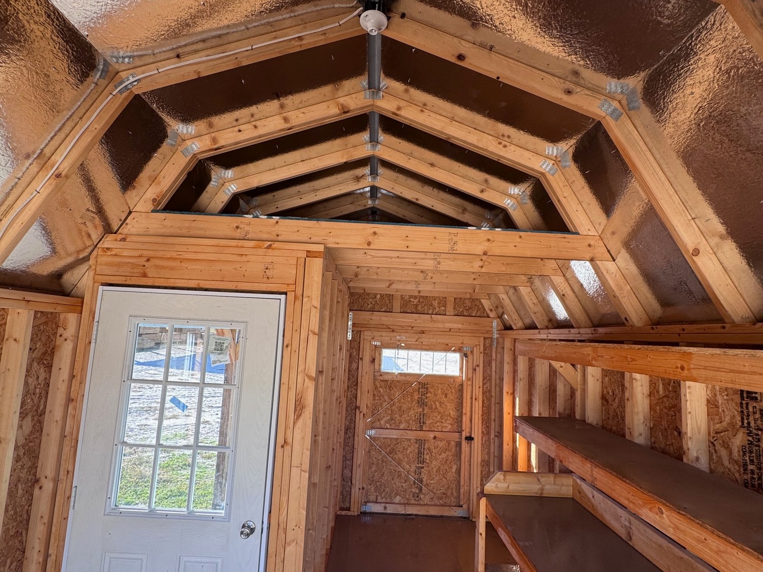 Interior loft view of 10x16 Lofted Barn Cabin with radiant barrier roof and workbench shelving