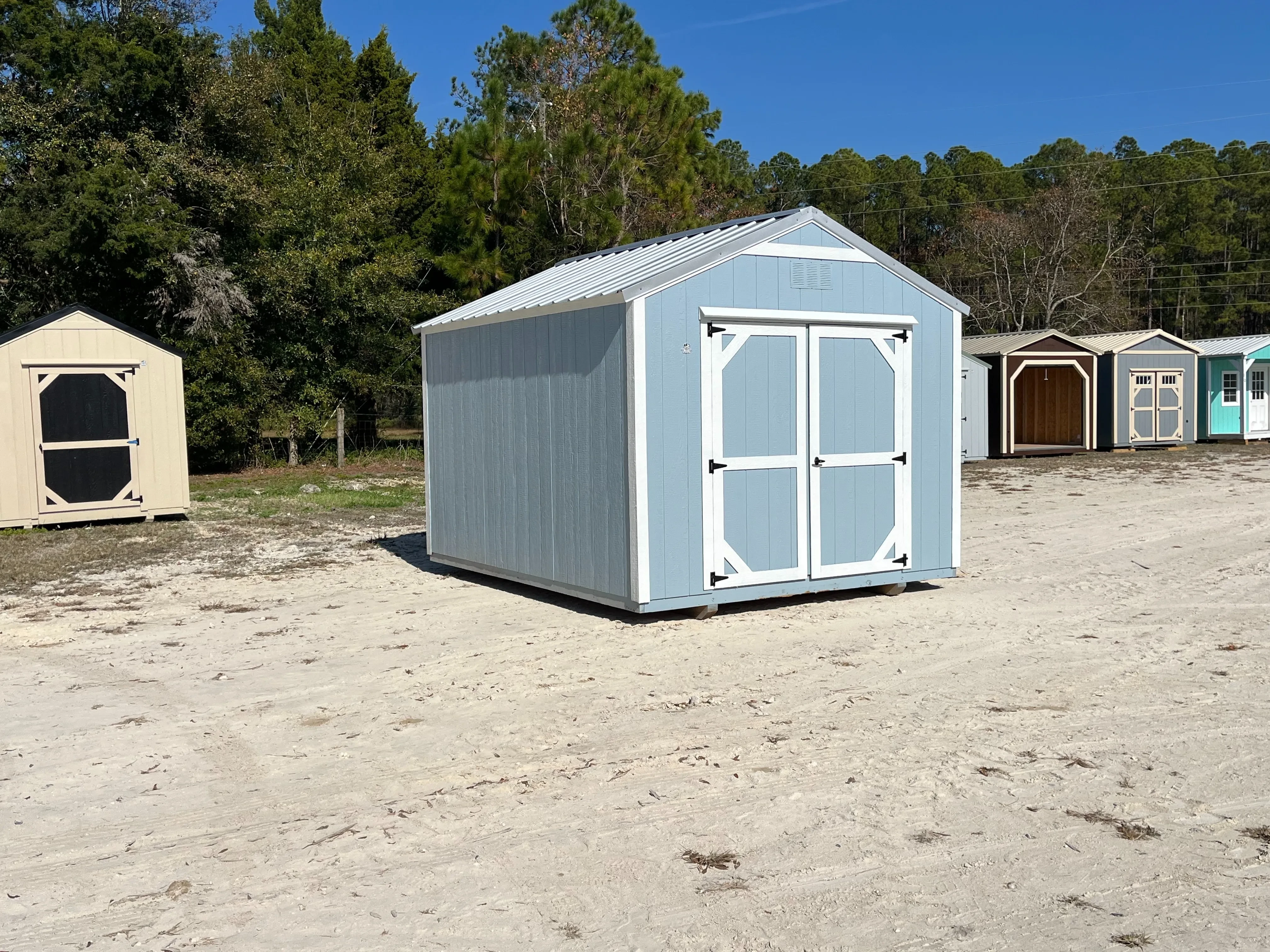 Exterior left side of a light blue 10x12 Garden Shed Economy with double wood doors