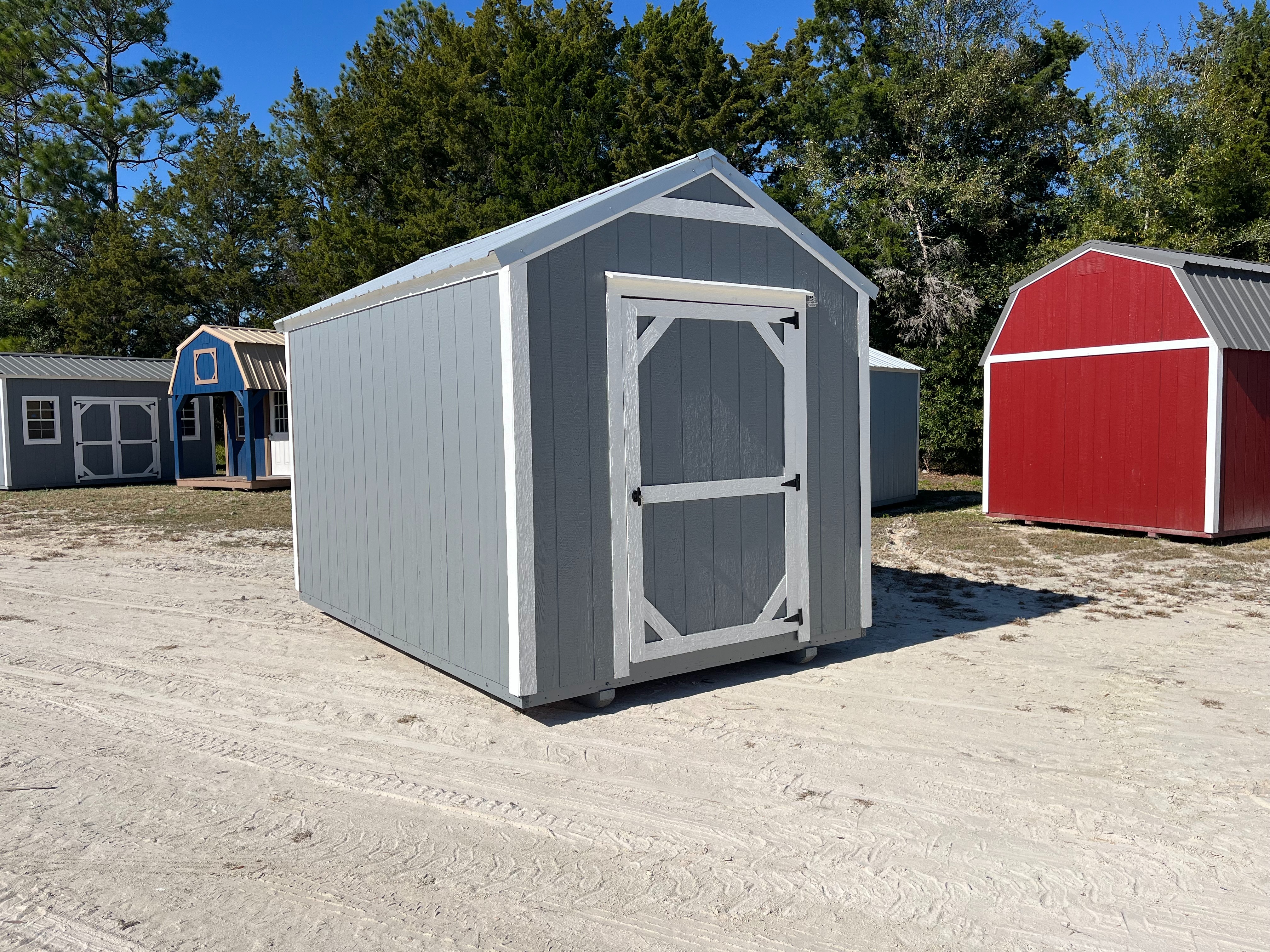 Exterior left side of a used dark grey 8x12 garden shed economy showing the wood door