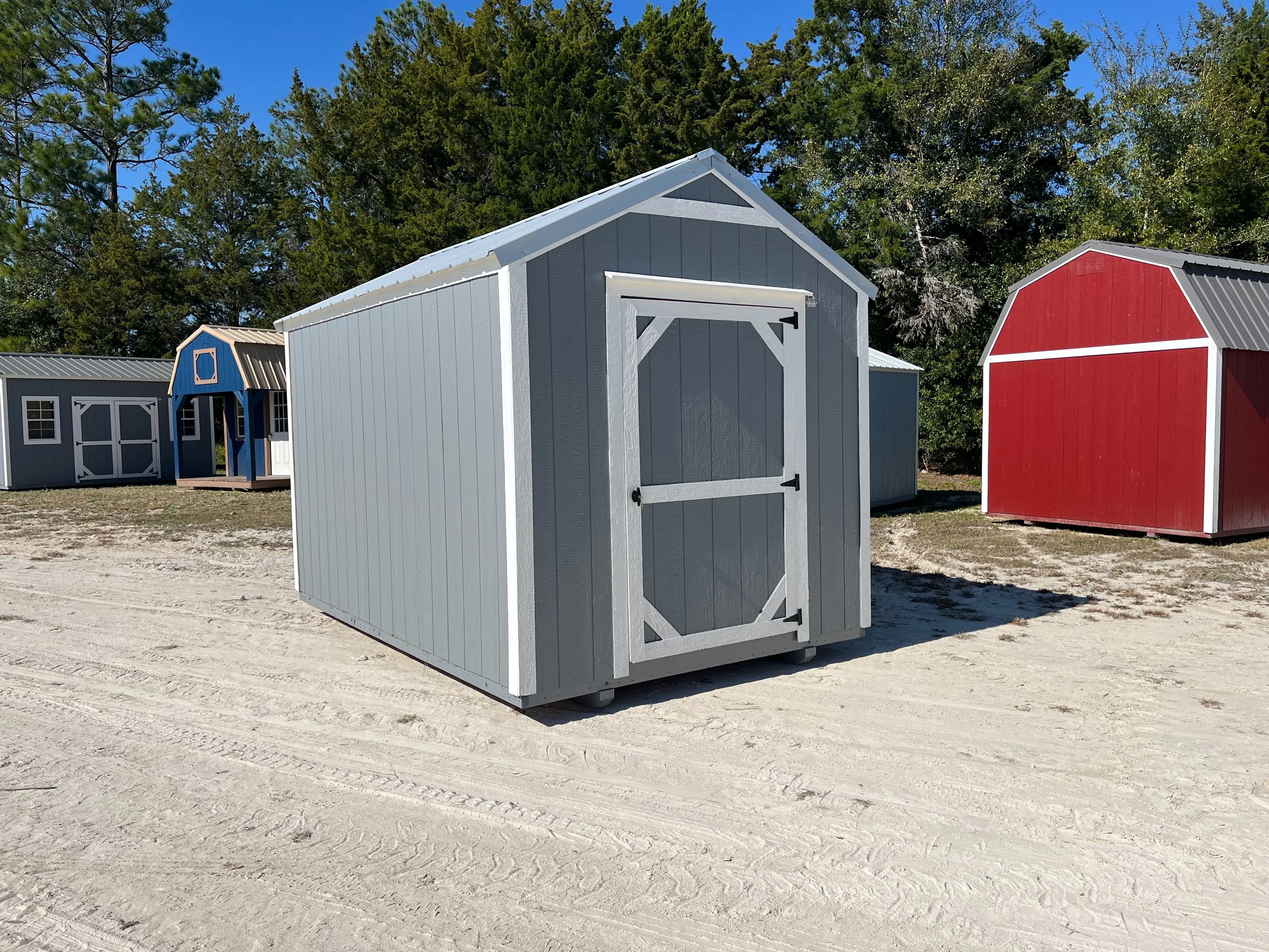 Exterior left side of a used dark grey 8x12 garden shed economy showing the wood door