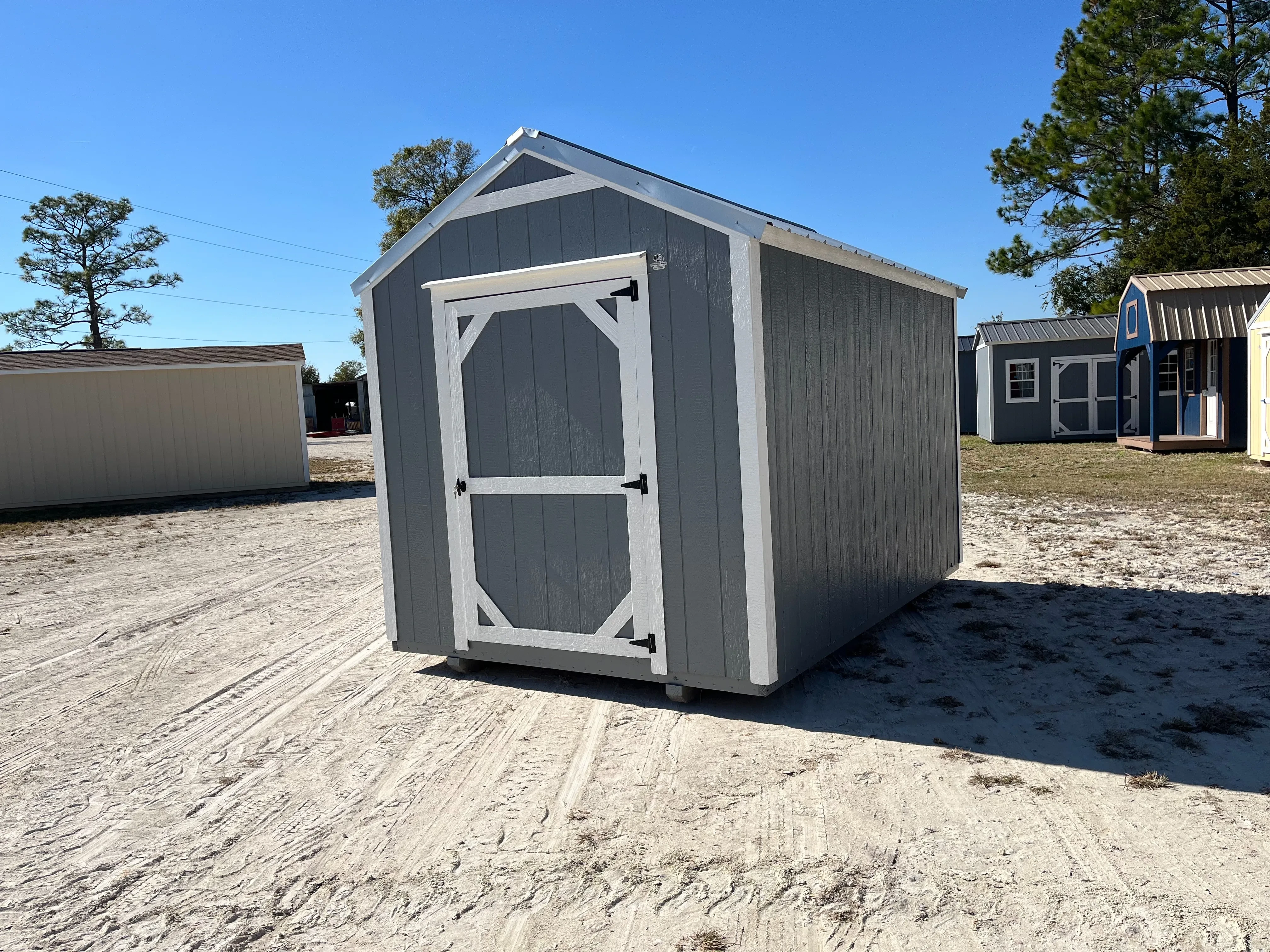 Exterior right side of a used dark grey 8x12 garden shed economy showing the wood door