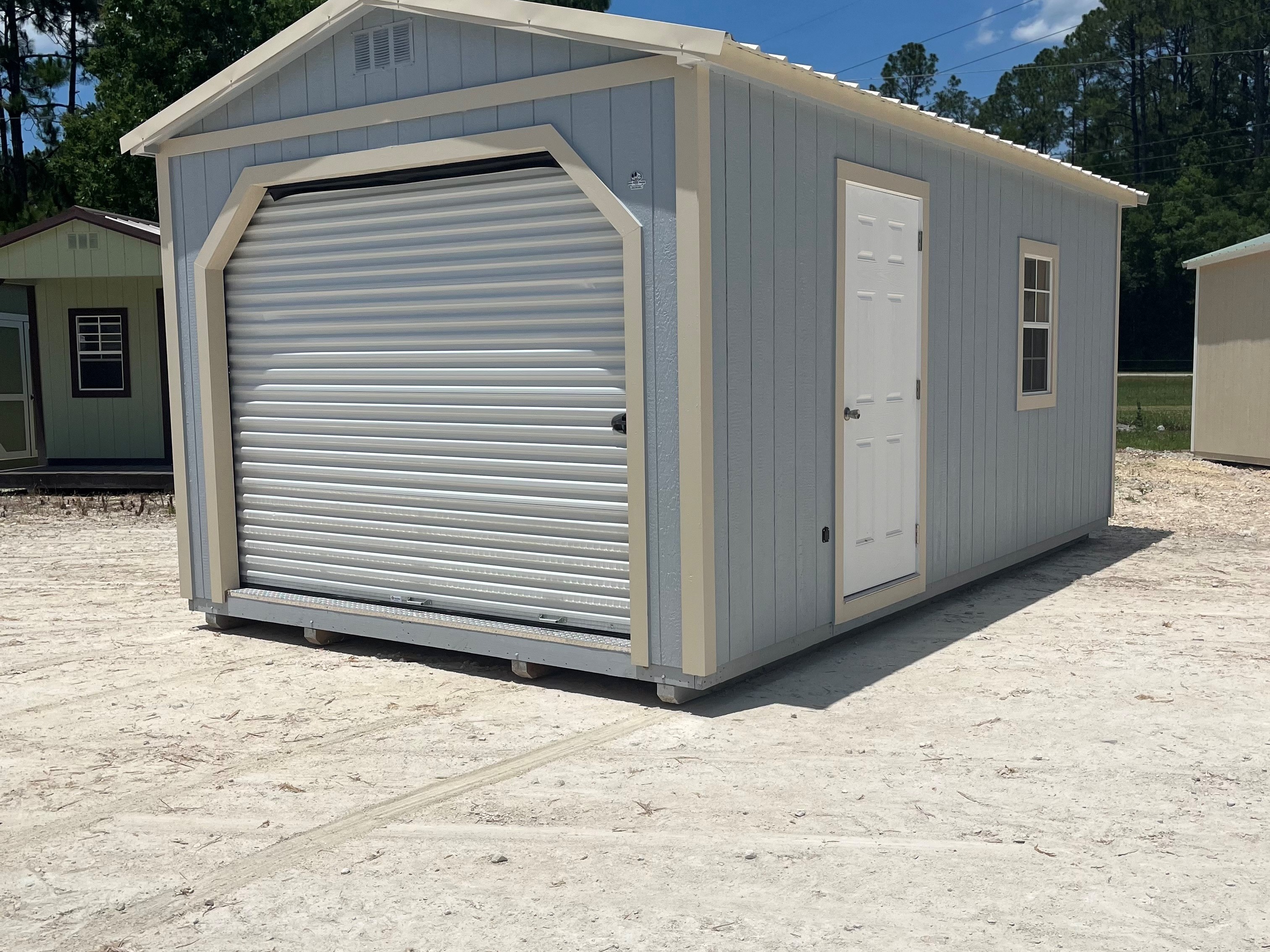 Exterior of a li grey 12x20 workshop with a walk-in door, window and roll up door