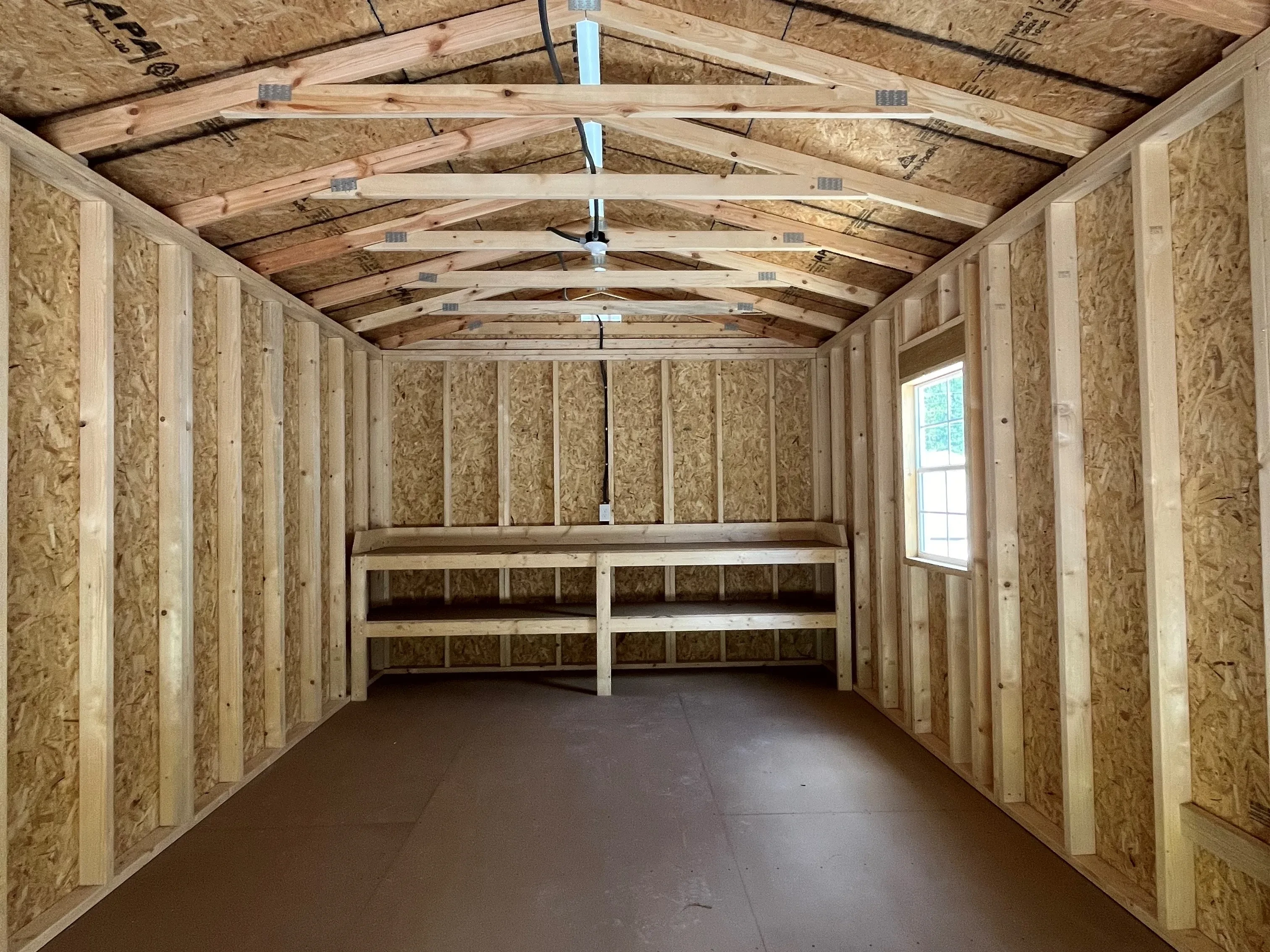 Interior view of a 12x20 workshop showing the window, walk-in door and workbench