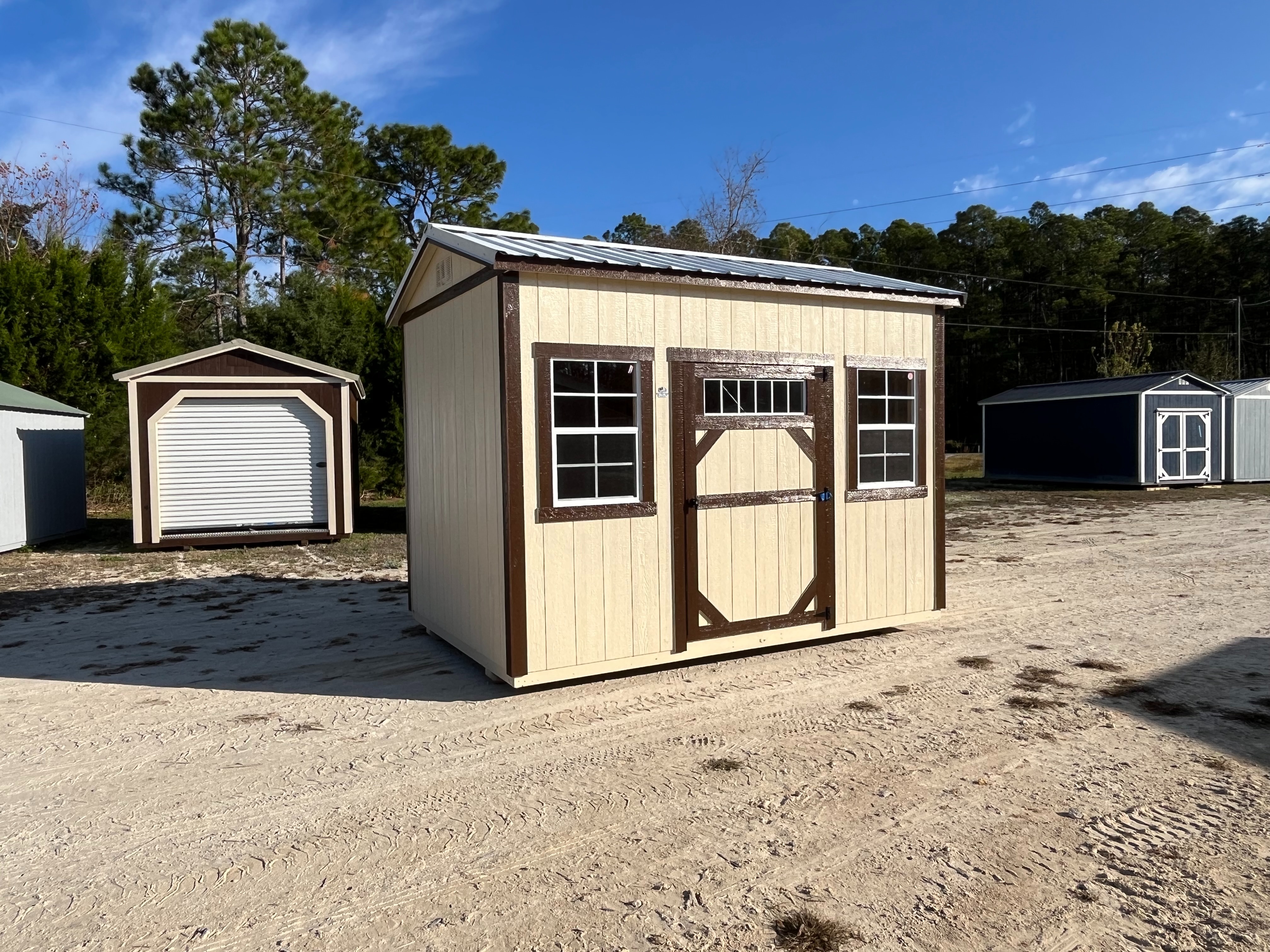 Exterior view of almond and brown 8x12 side garden shed showing a wood door with window and windows