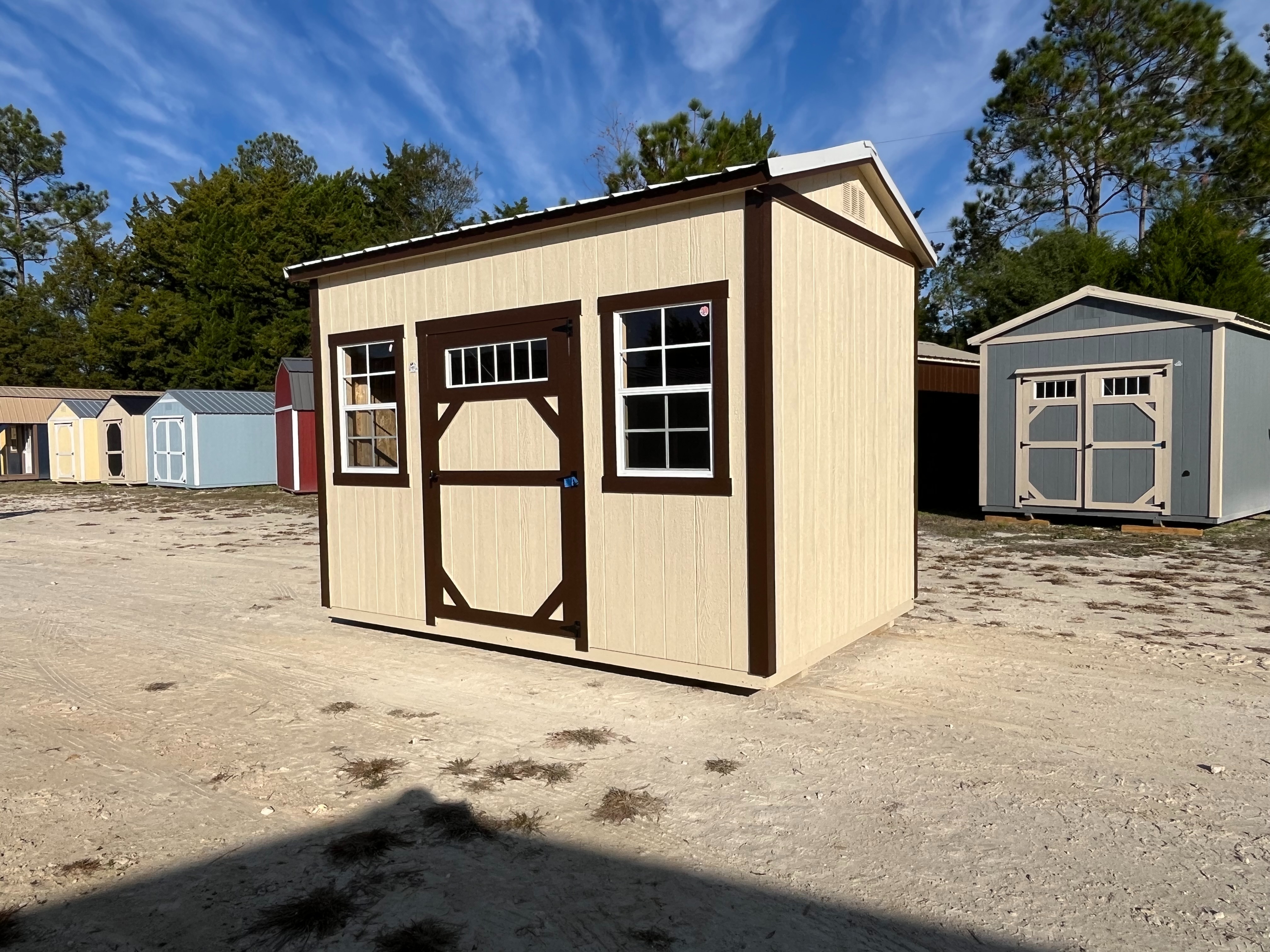 Exterior view of almond and brown 8x12 side garden shed showing a wood door with window and windows