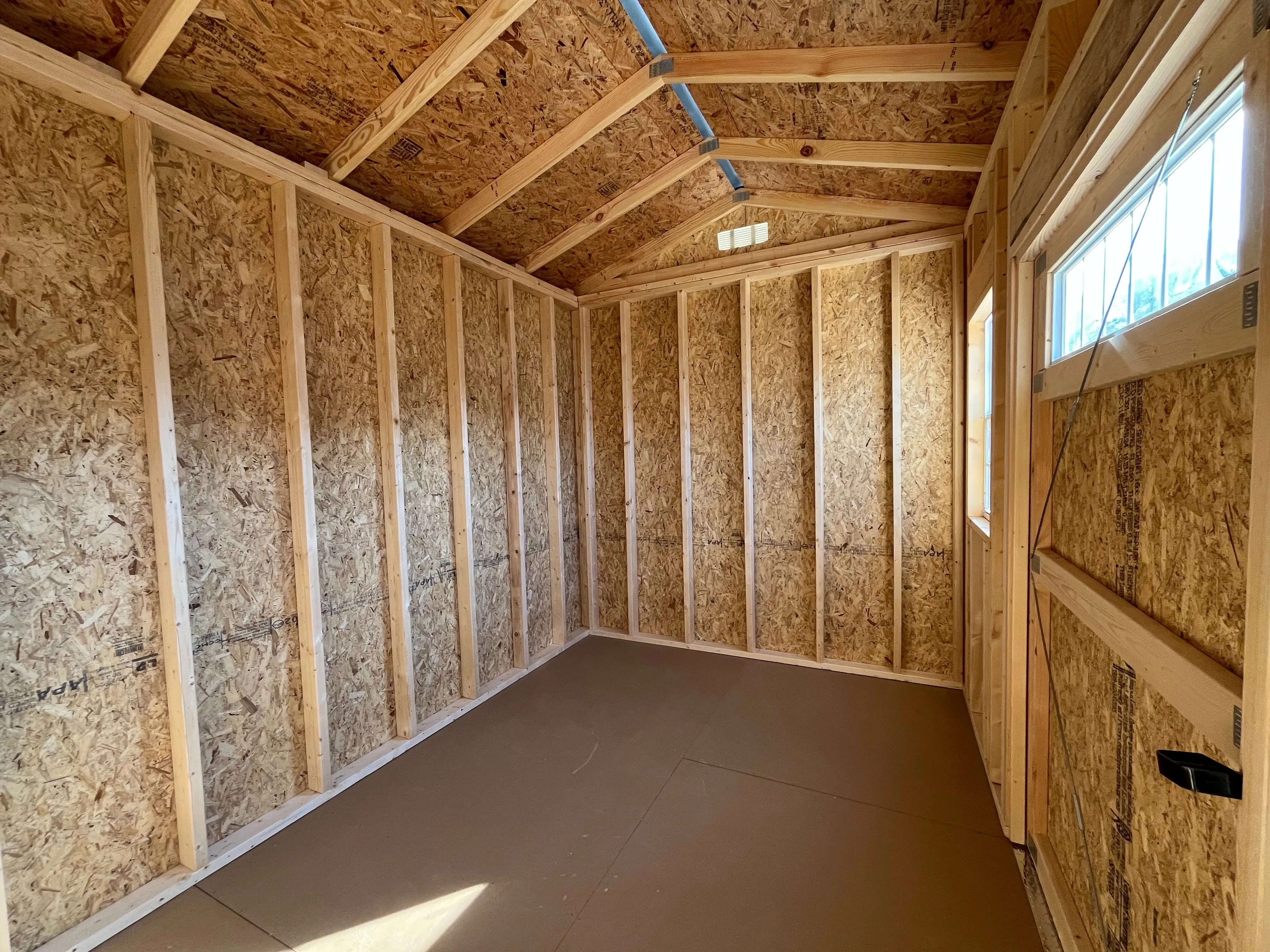 Interior view of an 8x12 side garden shed showing door and window
