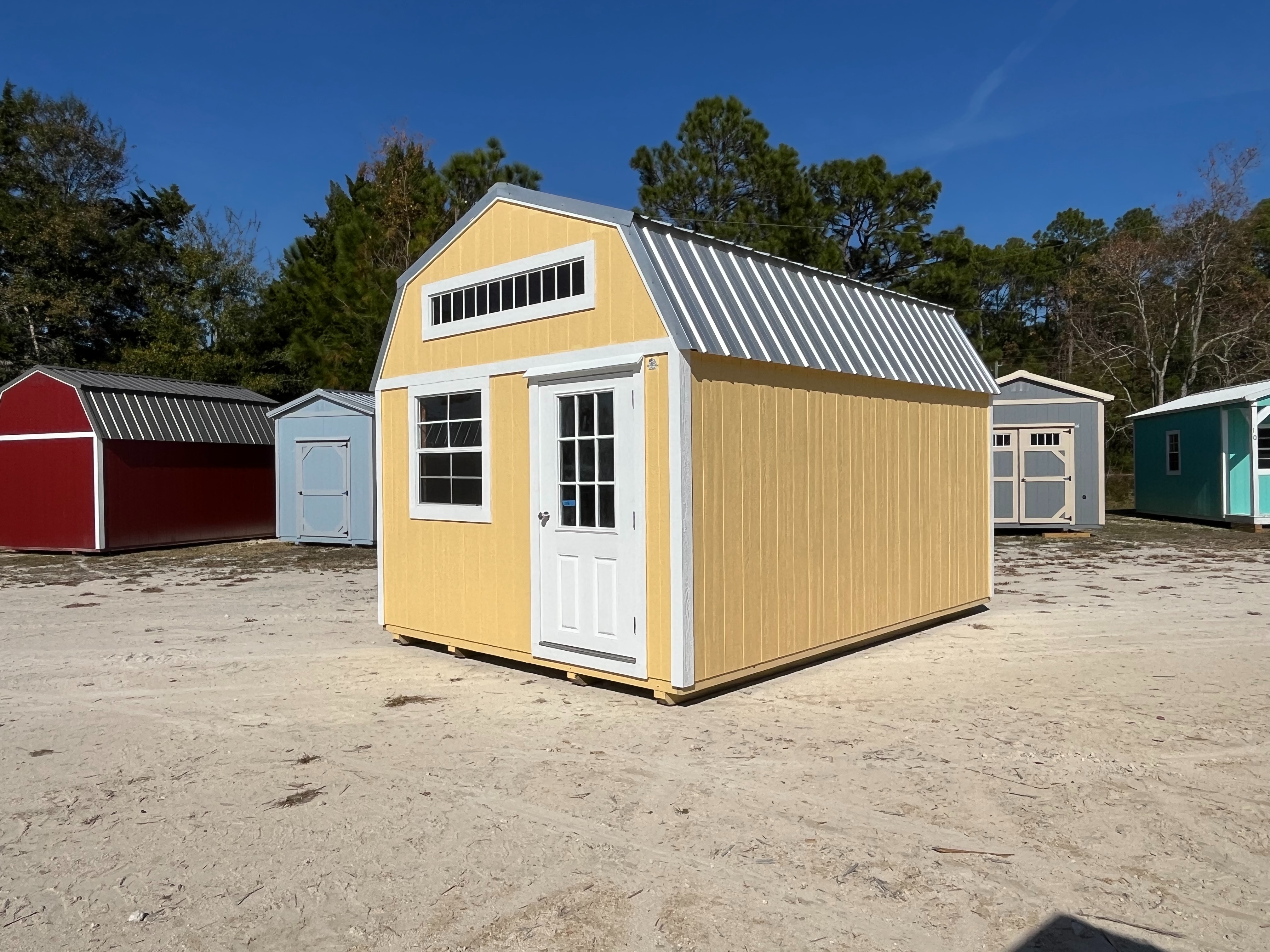 Exterior front and right side view of a yellow 12x16 lofted barn with a walk-in door and windows