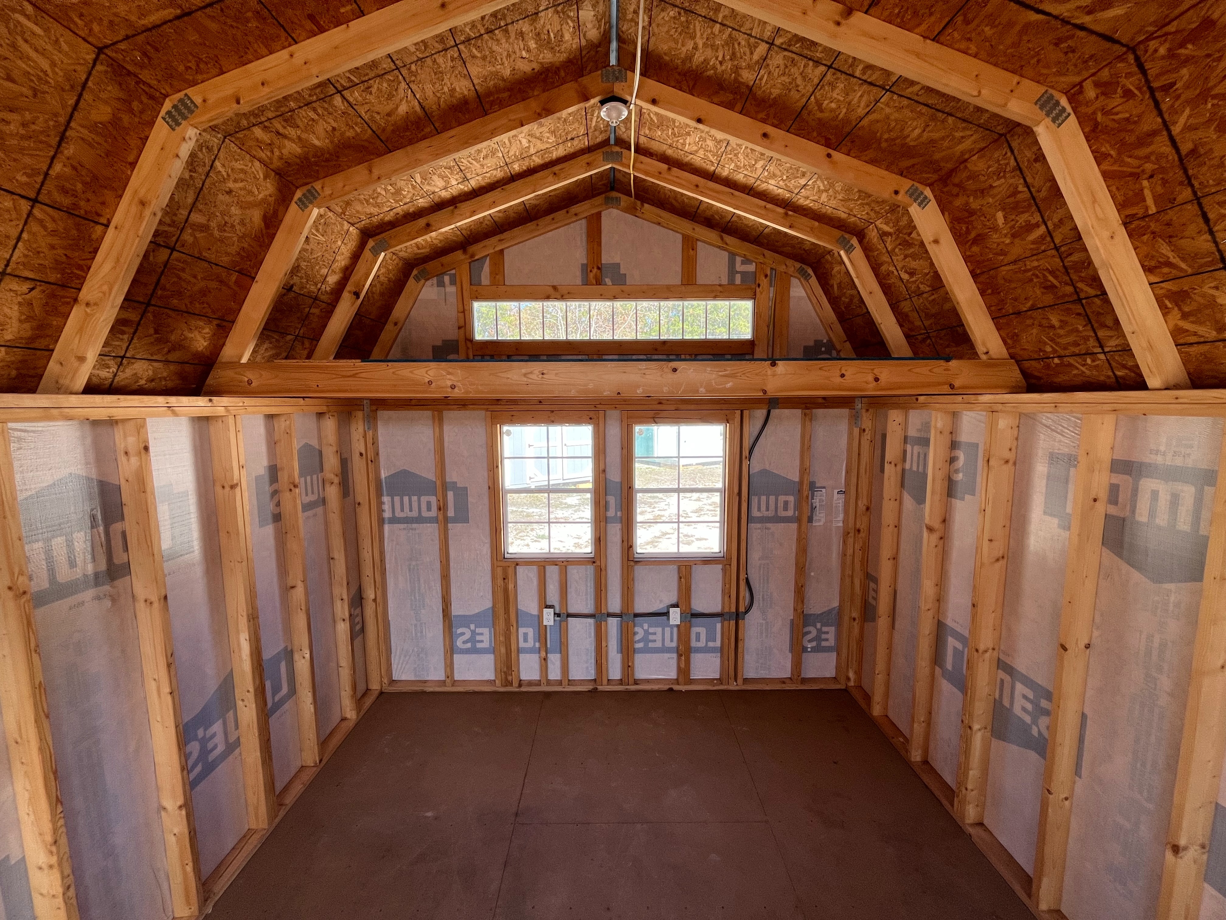 Interior back wall view of a 12x16 lofted barn showing the windows, loft, any many more features