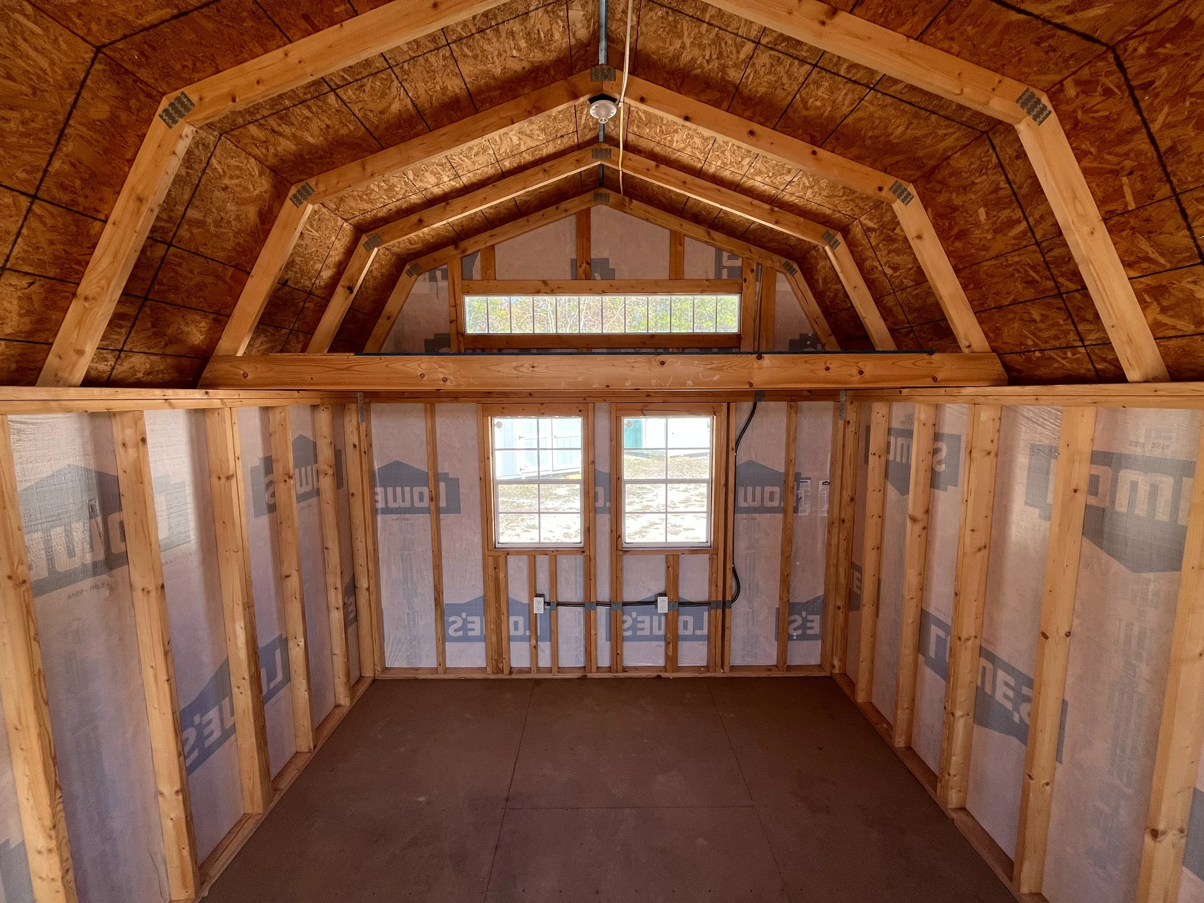 Interior back wall view of a 12x16 lofted barn showing the windows, loft, any many more features
