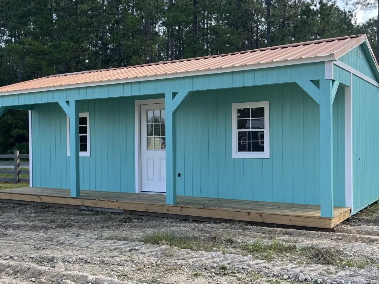 Exterior of a 14x28 side porch cabin showing walk-in door and windows