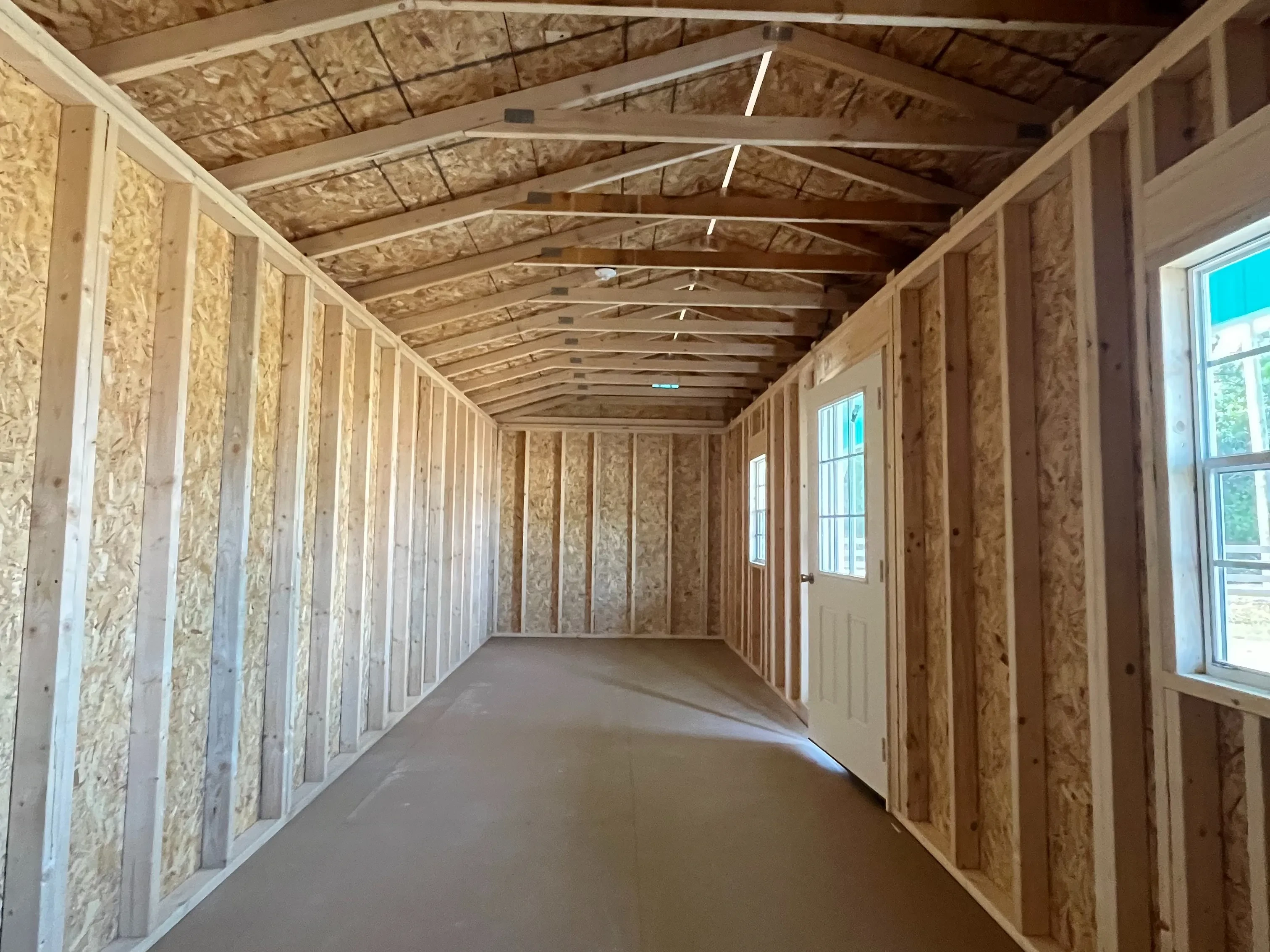 Interior of a 14x28 side porch cabin showing walk-in door and windows