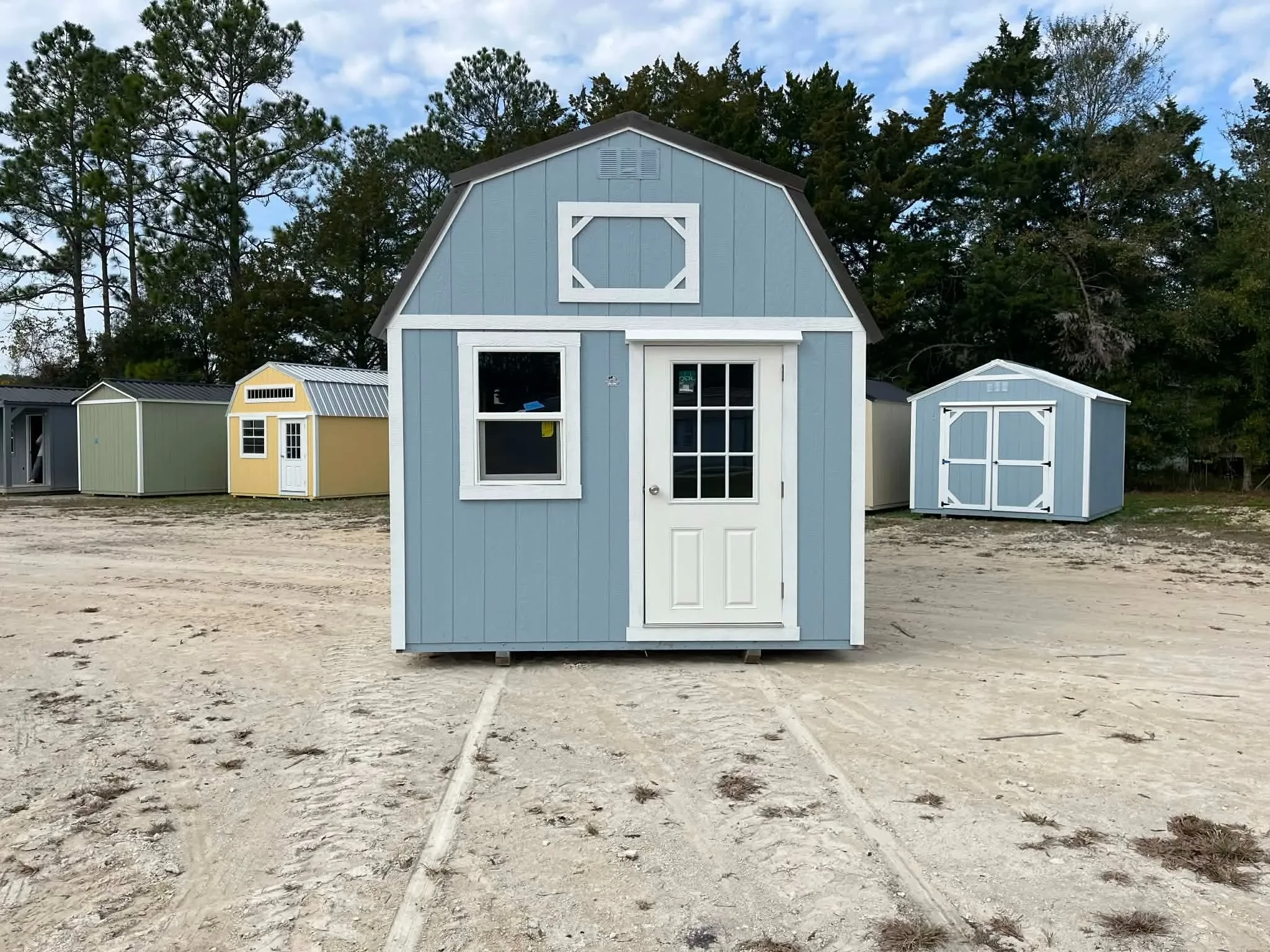 Exterior front of a light blue 10x24 lofted barn with a walk-in door and window