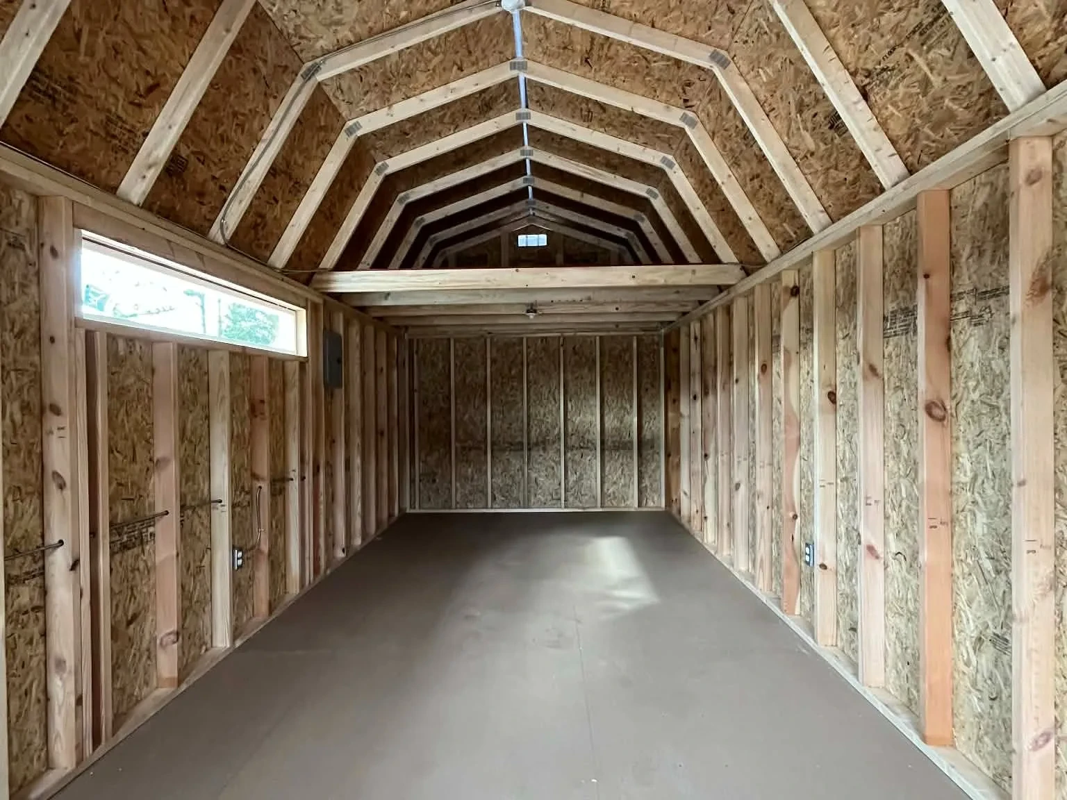Interior of a 10x24 viewing through the walk-in door showing the loft, transom and electric.