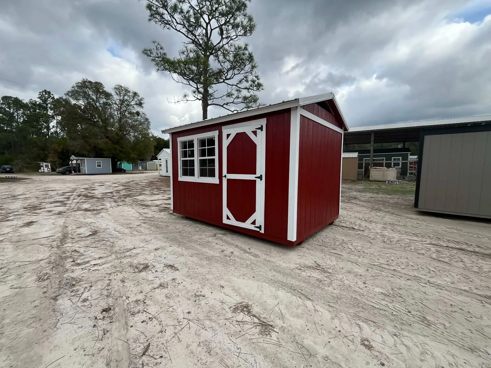 Exterior of a red 8x12 chicken coop showing the entry door and windows