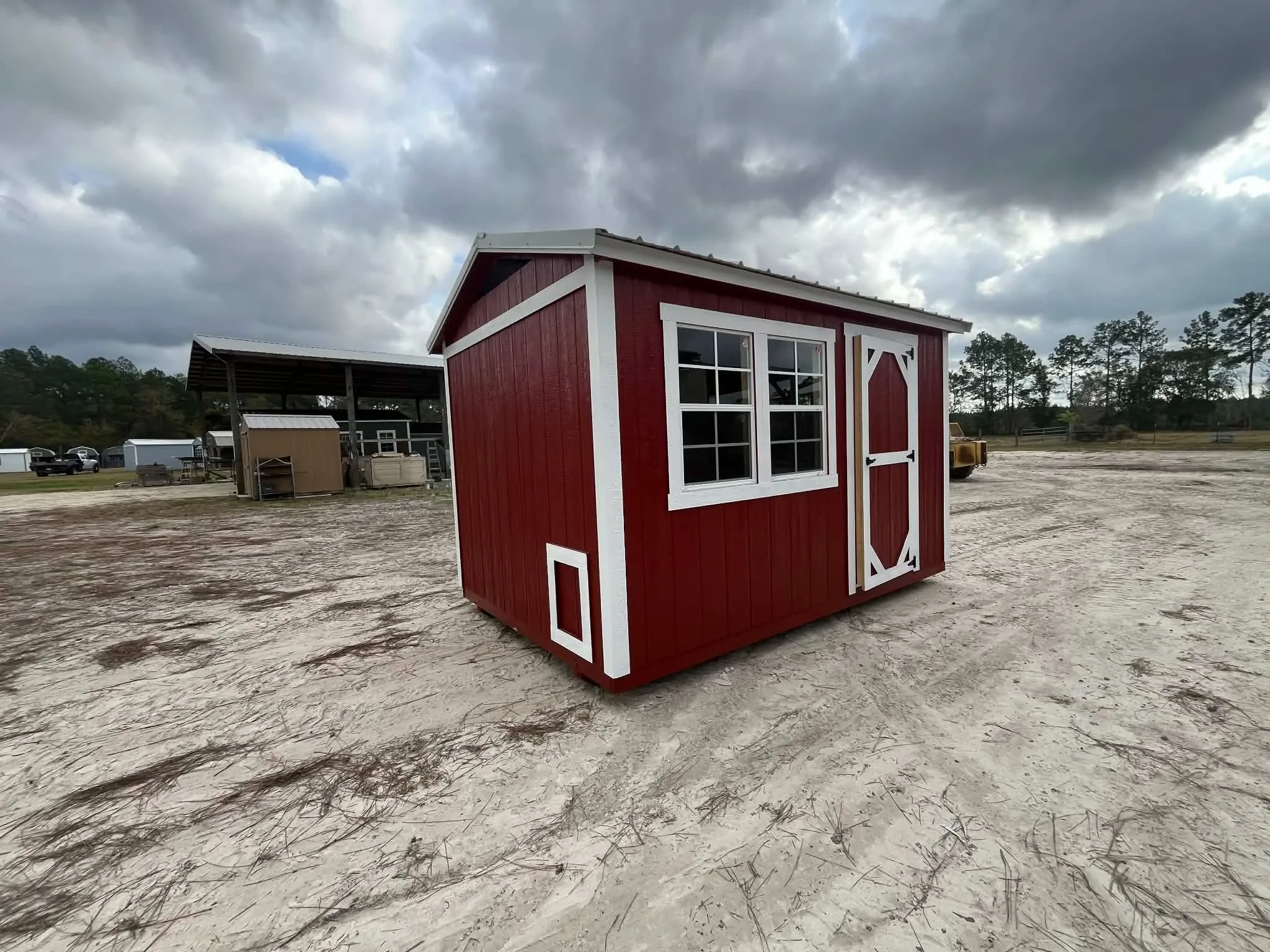 Exterior of a red 8x12 chicken coop showing the entry door. chicken access door and windows