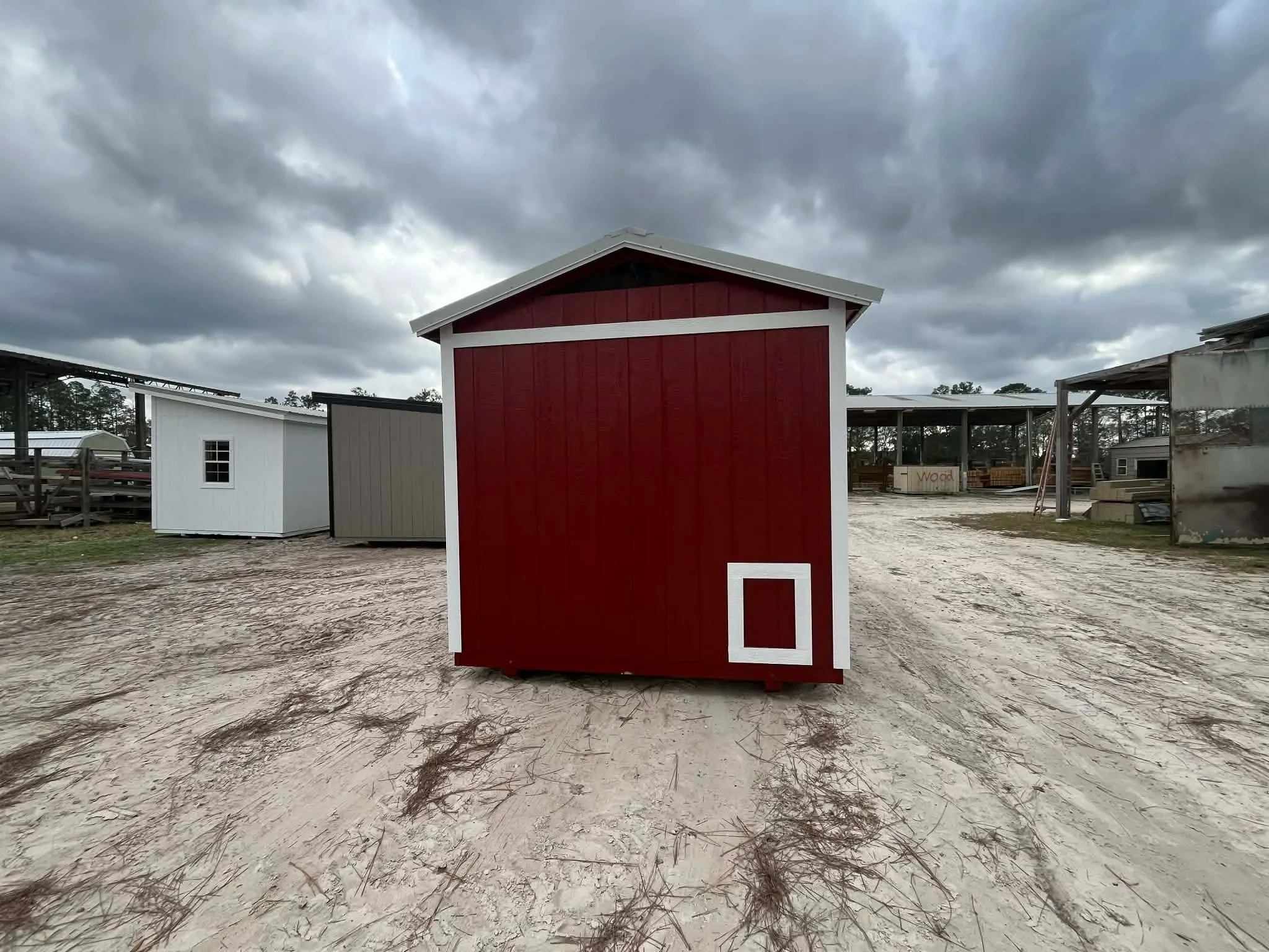 Exterior of a red 8x12 chicken coop showing the chicken access door