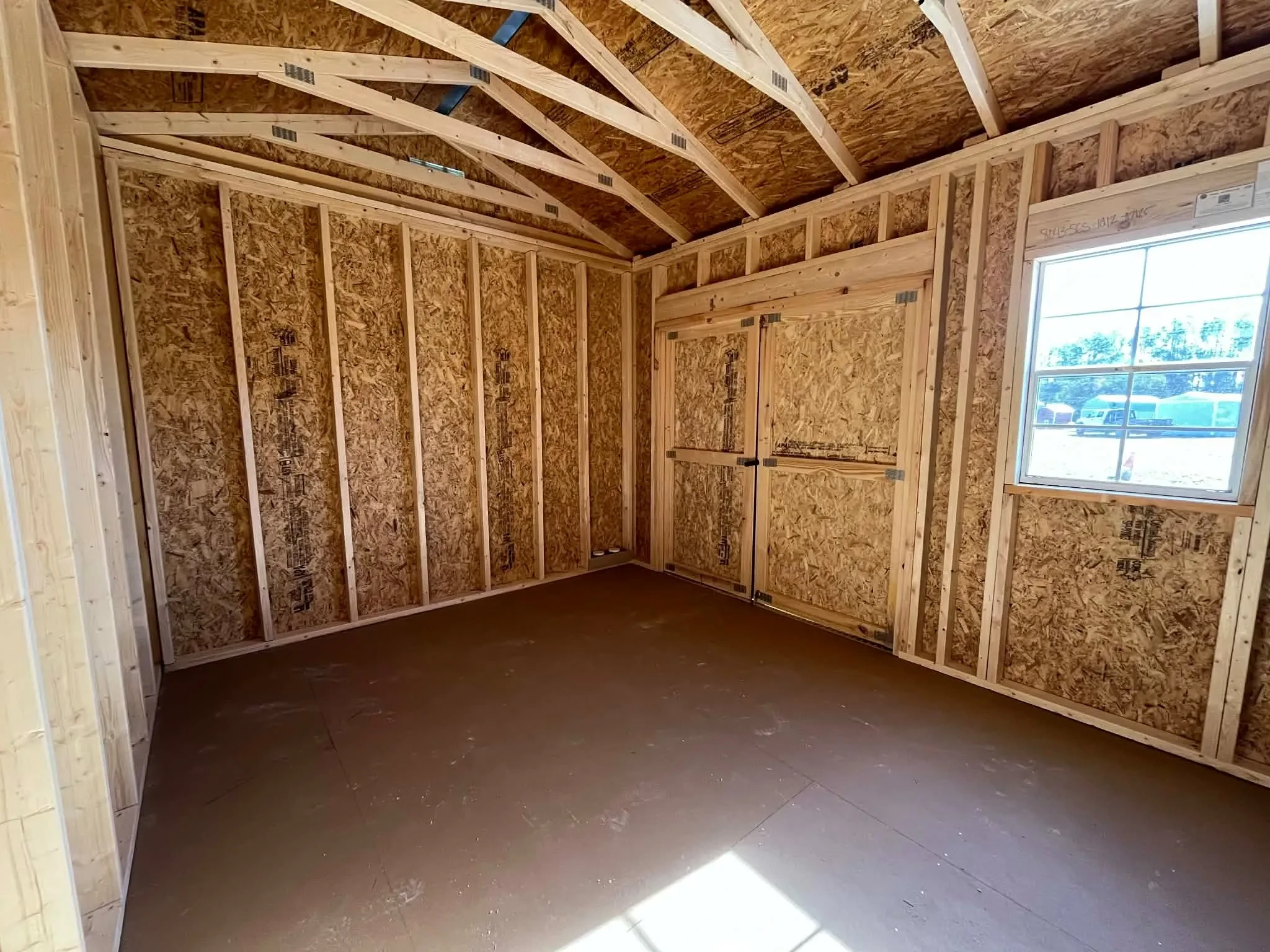 Interior view of a 10x12 side garden shed showing doors and window