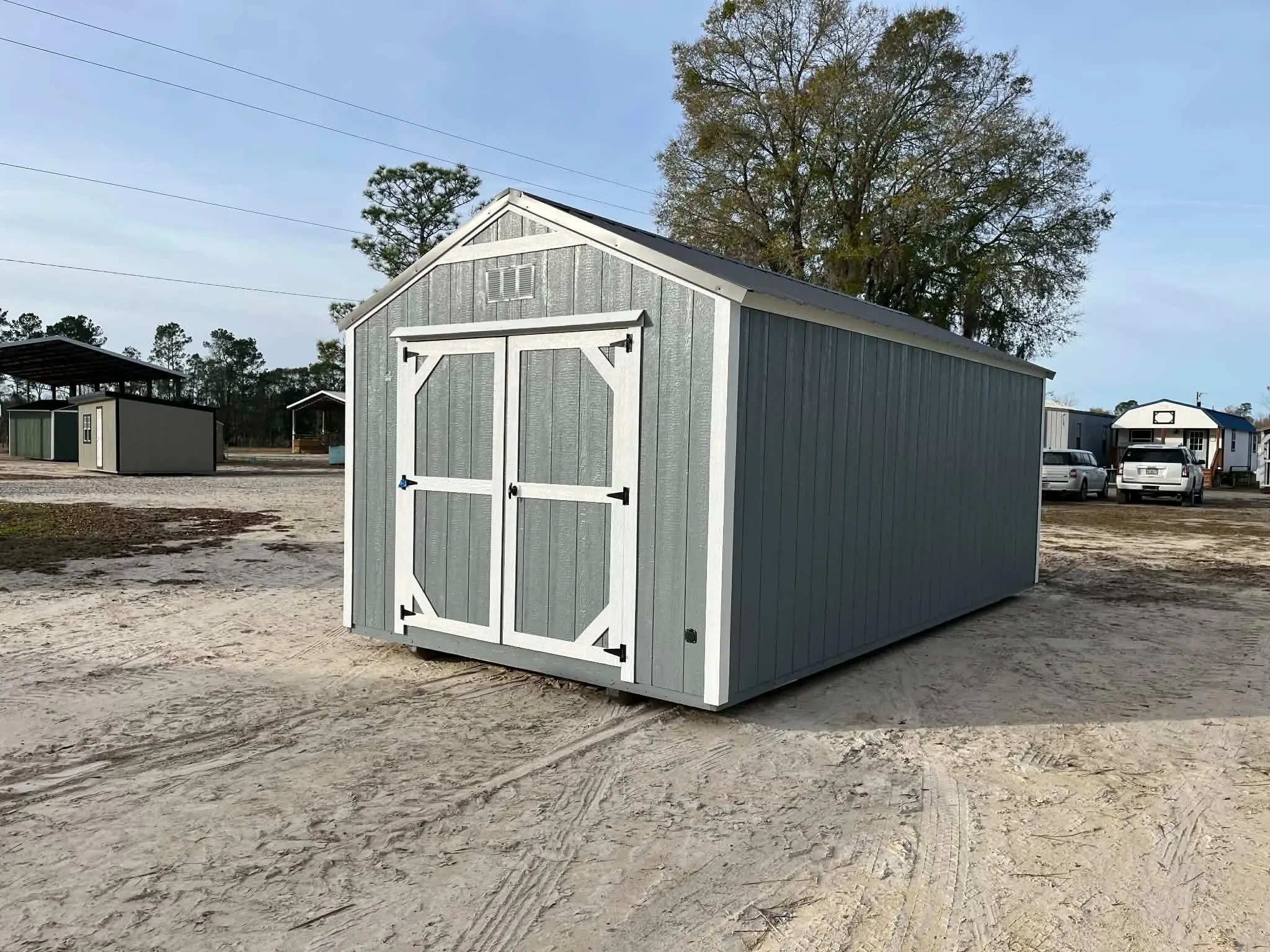 Exterior view of a dark grey garden shed economy with wood doors