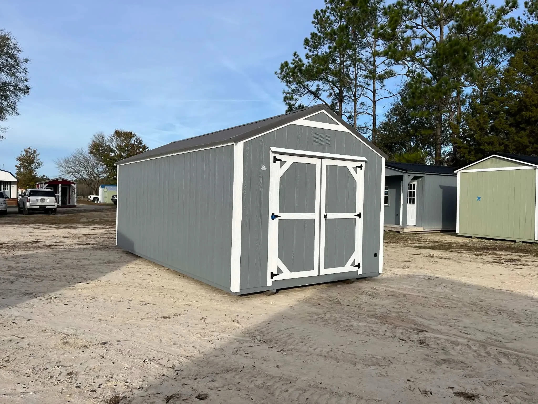 Exterior view of a dark grey garden shed economy with wood doors