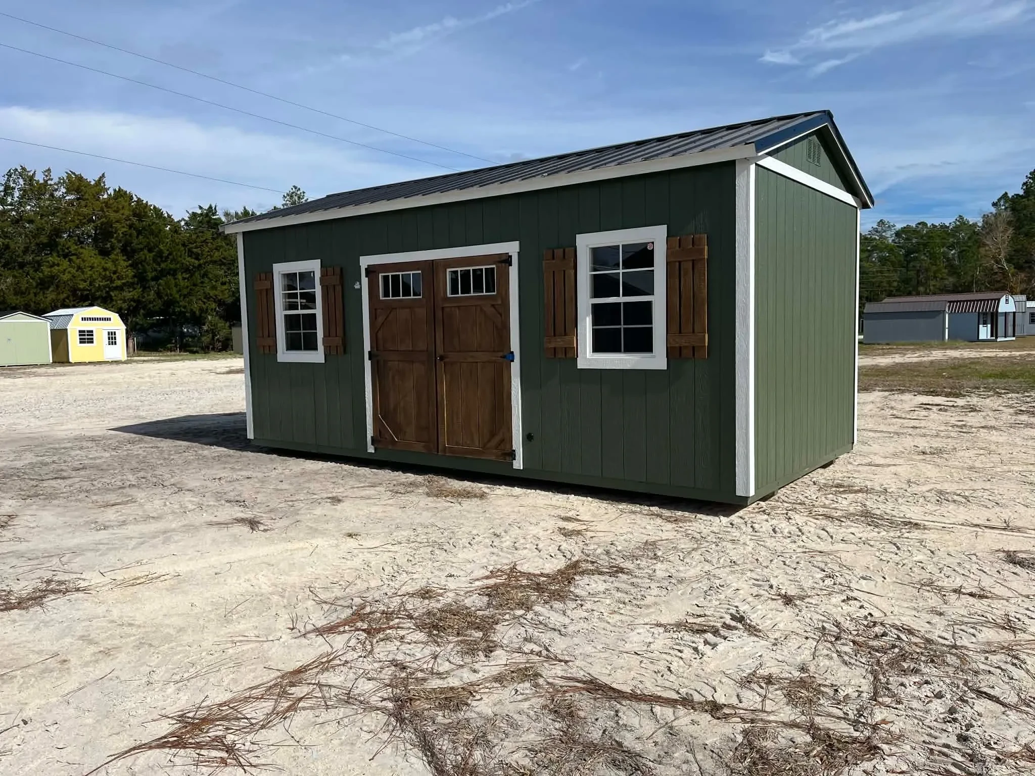 Exterior of a green 10x20 side garden shed showing doors and window