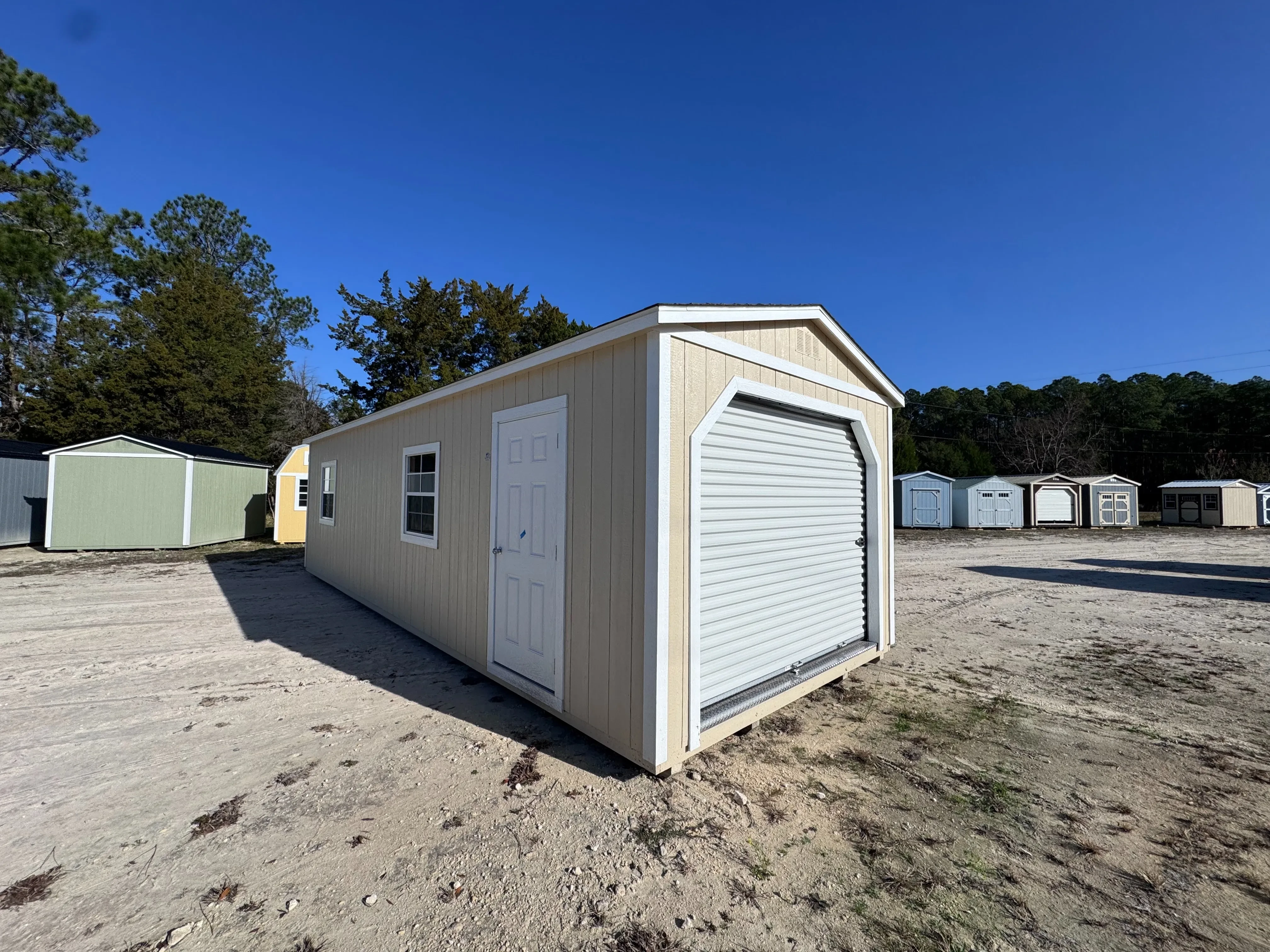 Almond 12x32 workshop with white trim and 8 foot roll up door, front corner view