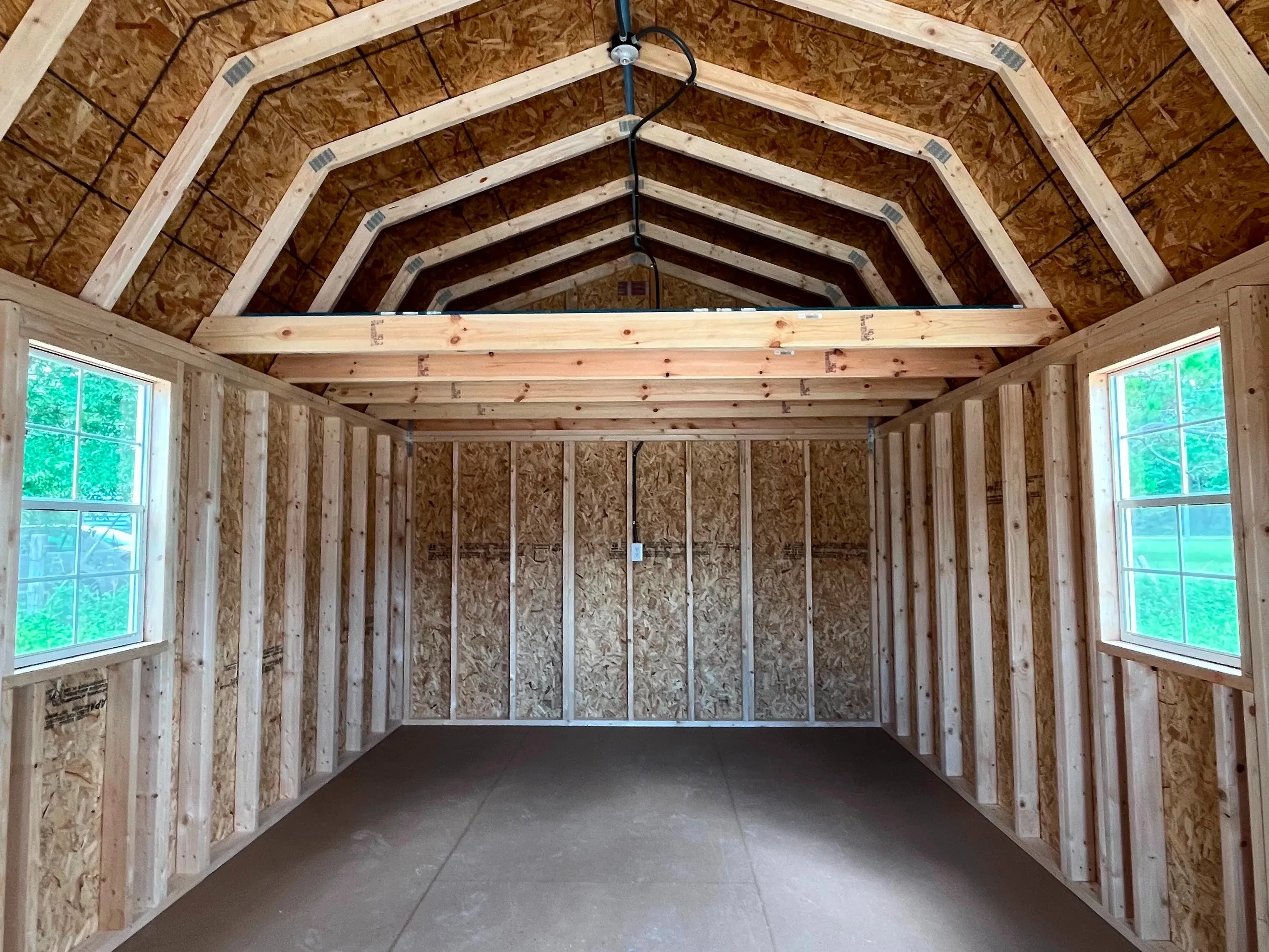 Interior of lofted barn cabin showing two windows and an eight foot loft in the back