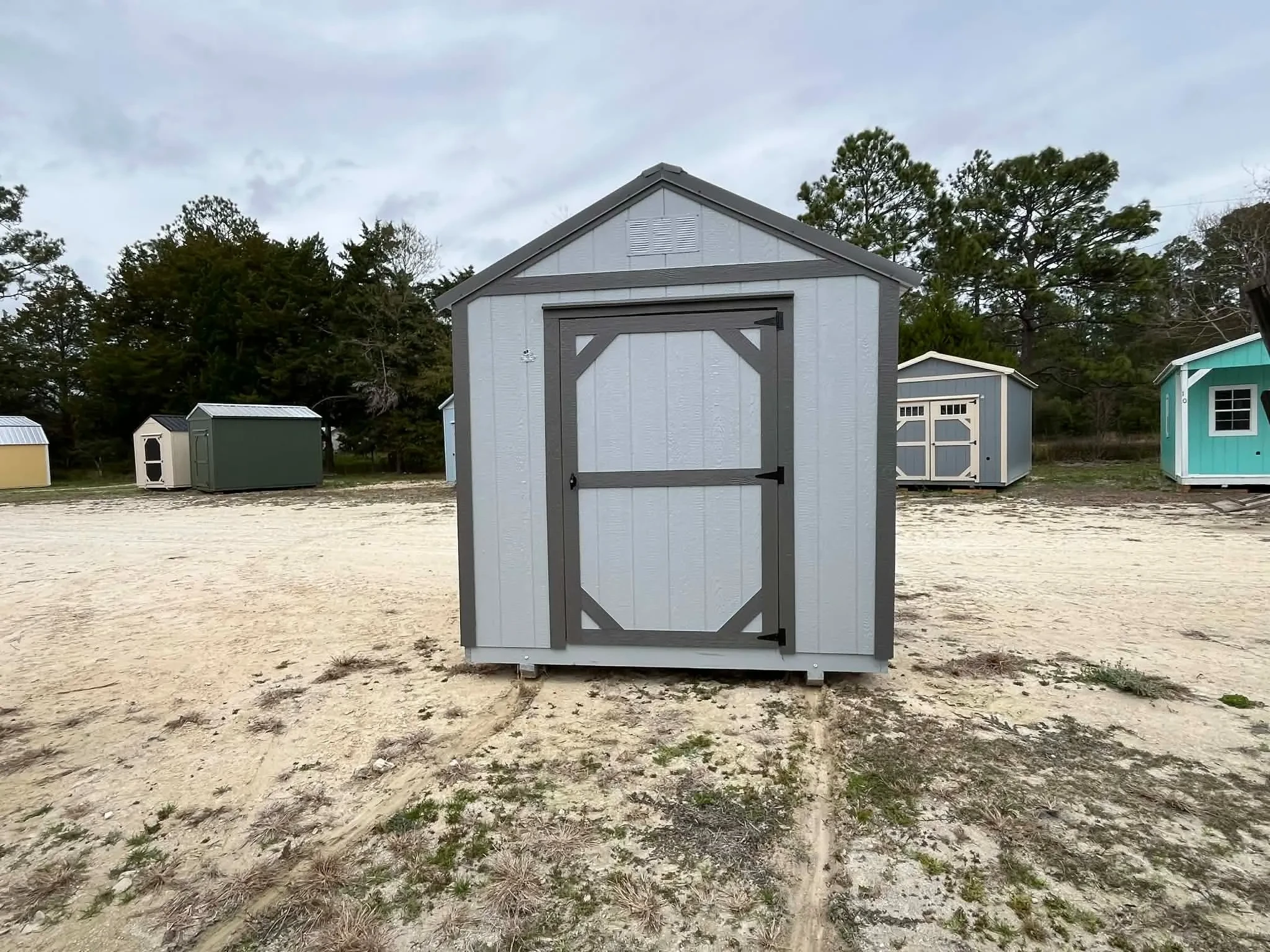 Exterior front of a light grey 8x12 garden shed economy showing a door