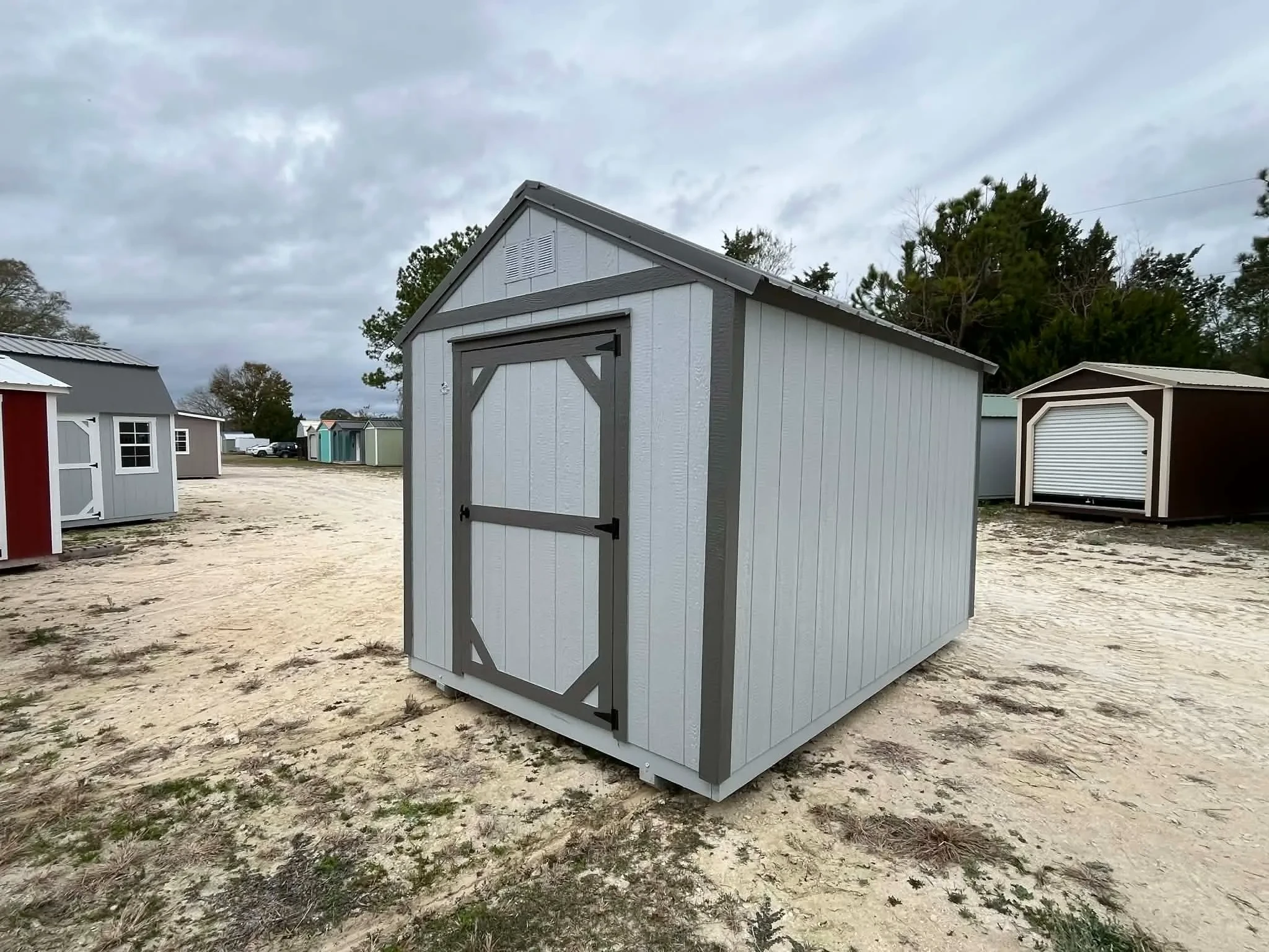 Exterior front of a light grey 8x12 garden shed economy showing a door