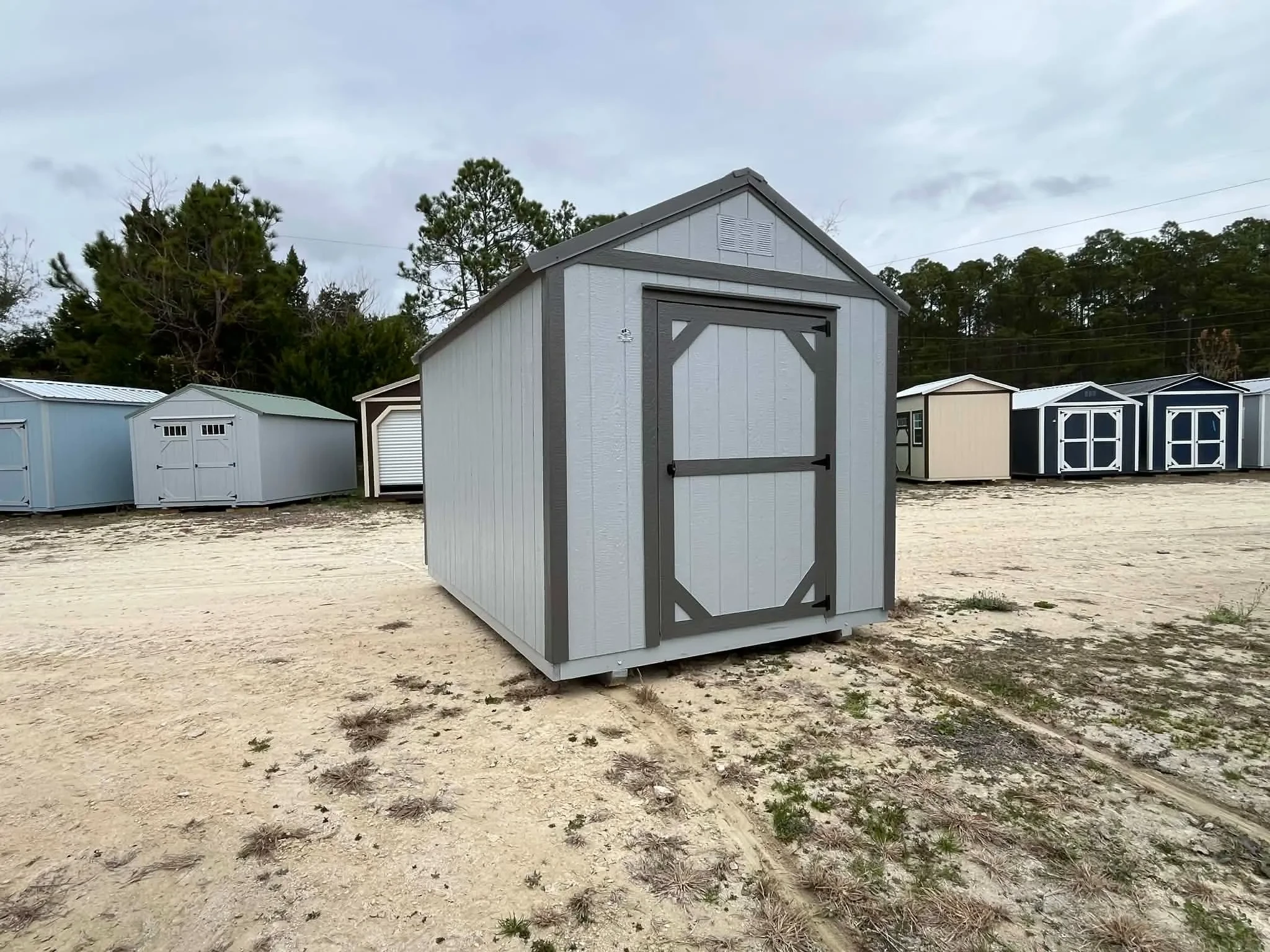Exterior front of a light grey 8x12 garden shed economy showing a door
