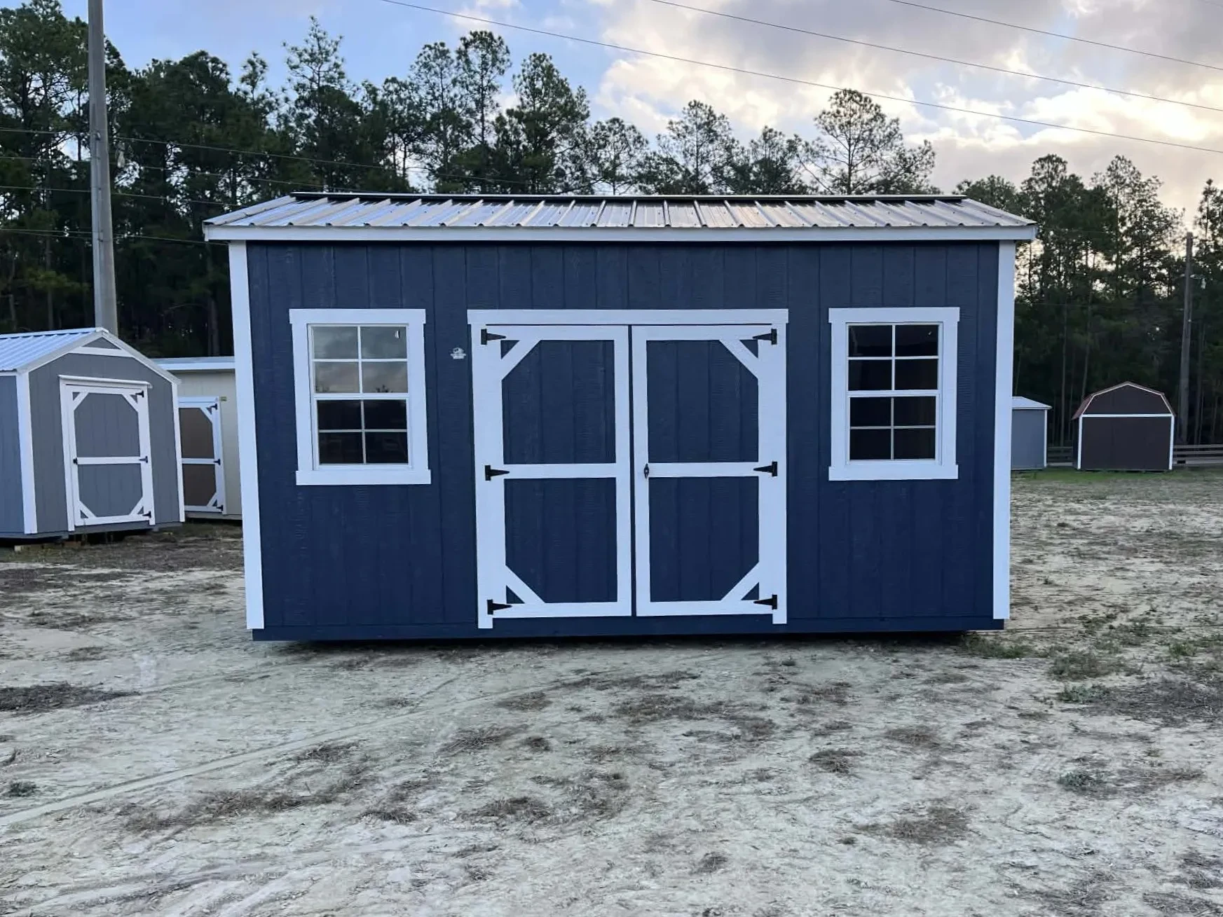 Exterior of a dark blue 10x16 side garden shed showing doors and window