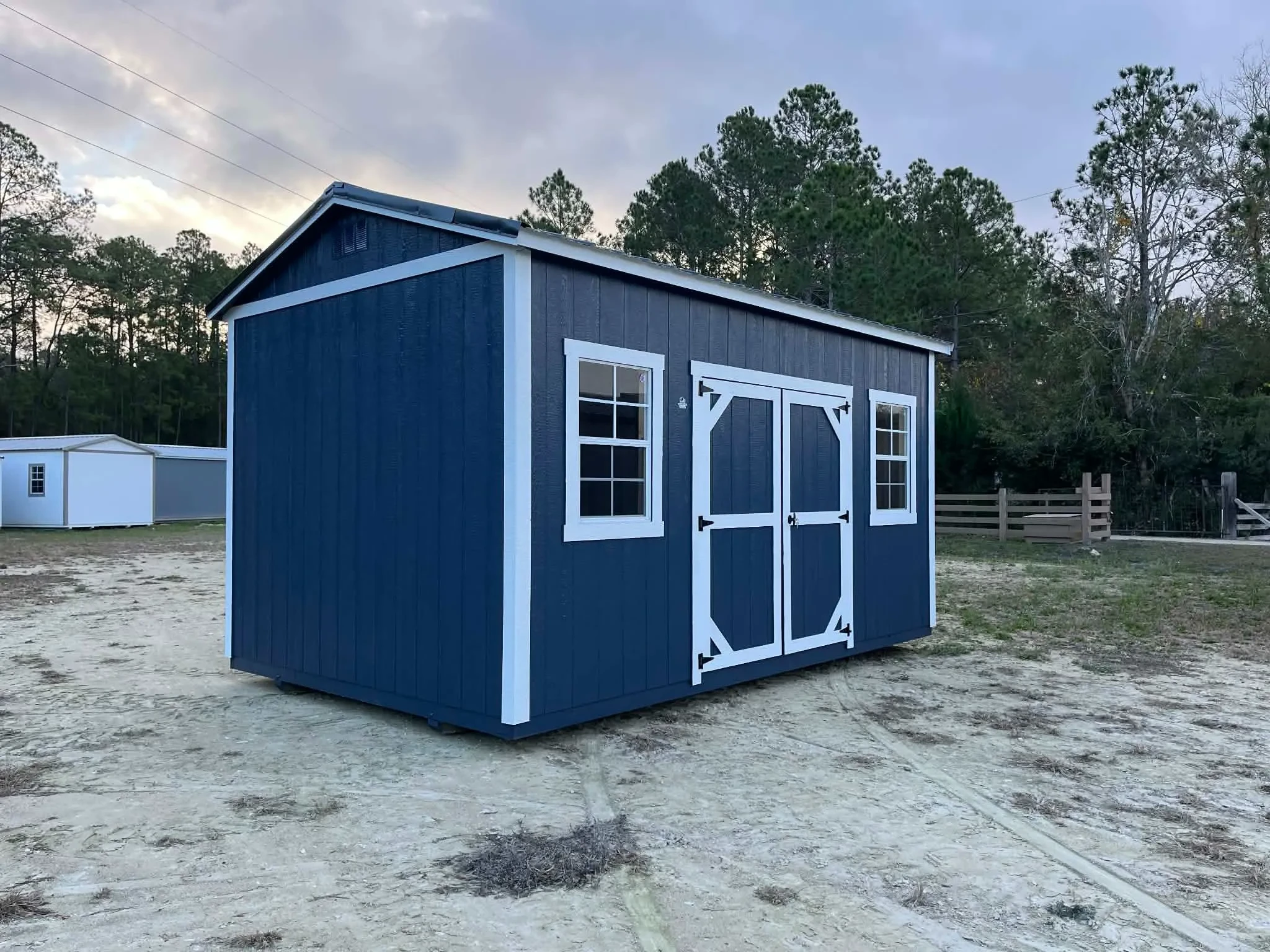 Exterior of a dark blue 10x16 side garden shed showing doors and window