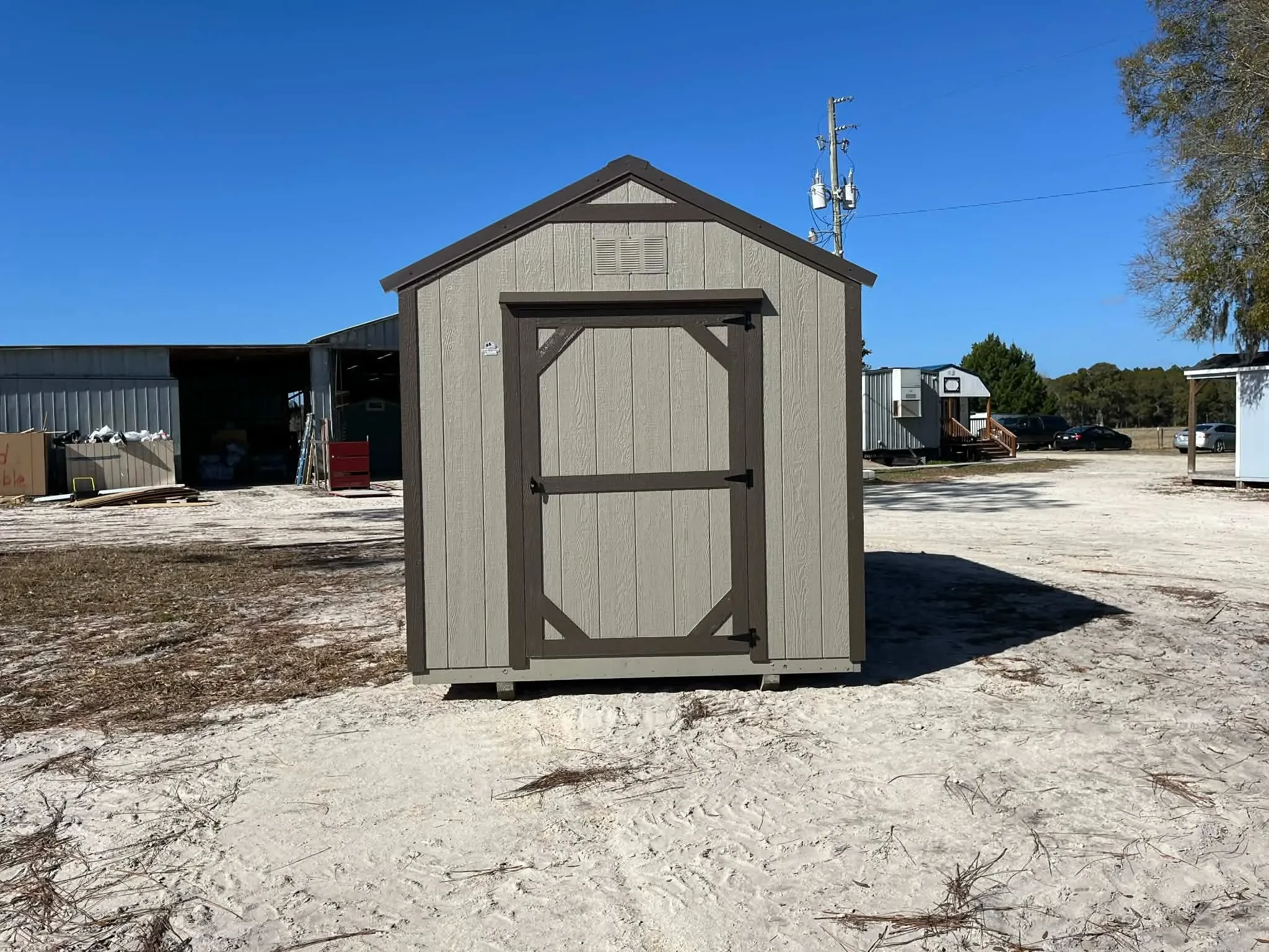 Exterior of a clay in color 8x12 garden shed economy with a wood door