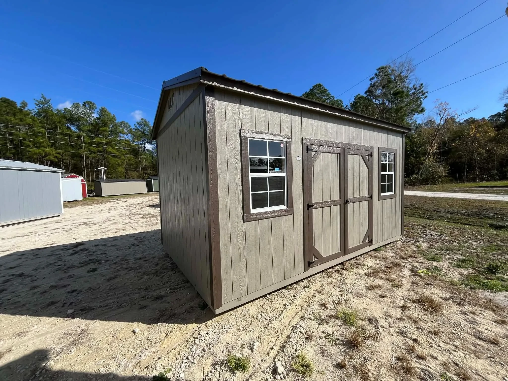 Exterior of a clay in color 10x16 side garden shed showing doors and windows