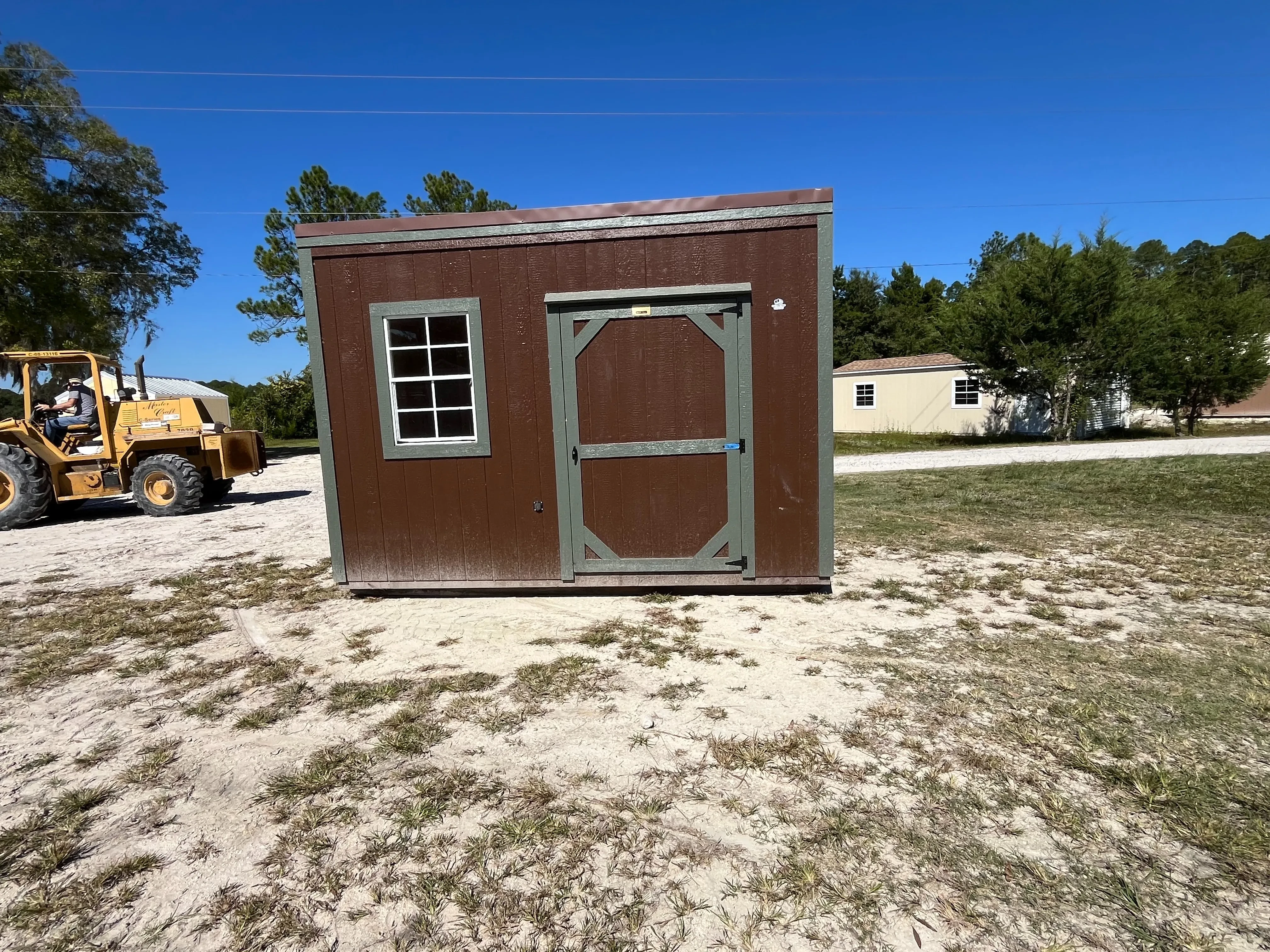 Exterior of a 6x12 brown urban with a wood door and window