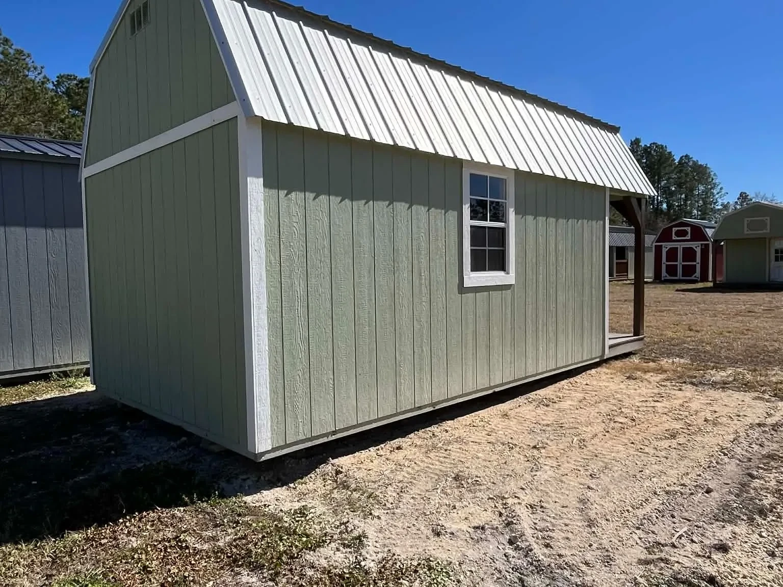 Exterior rear of a green 10x20 Lofted Barn Cabin showing a window