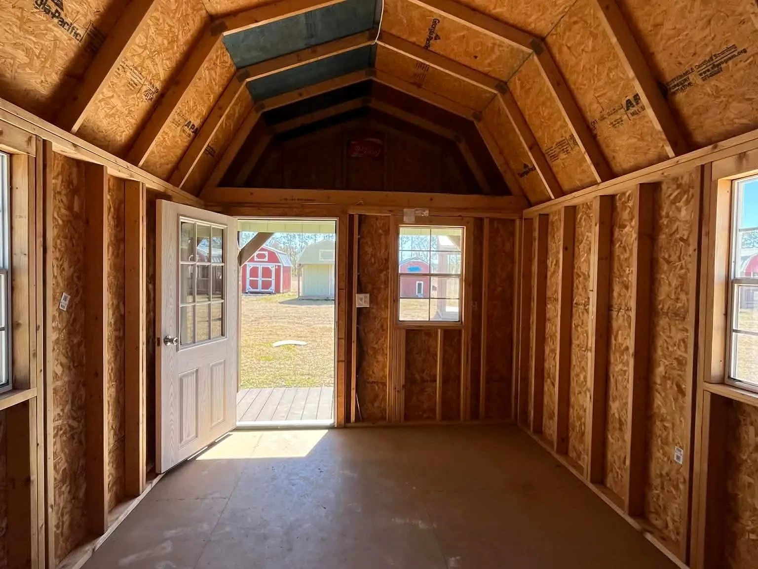 Interior of a 10x20 Lofted Barn Cabin showing the loft, walk-in door and windows