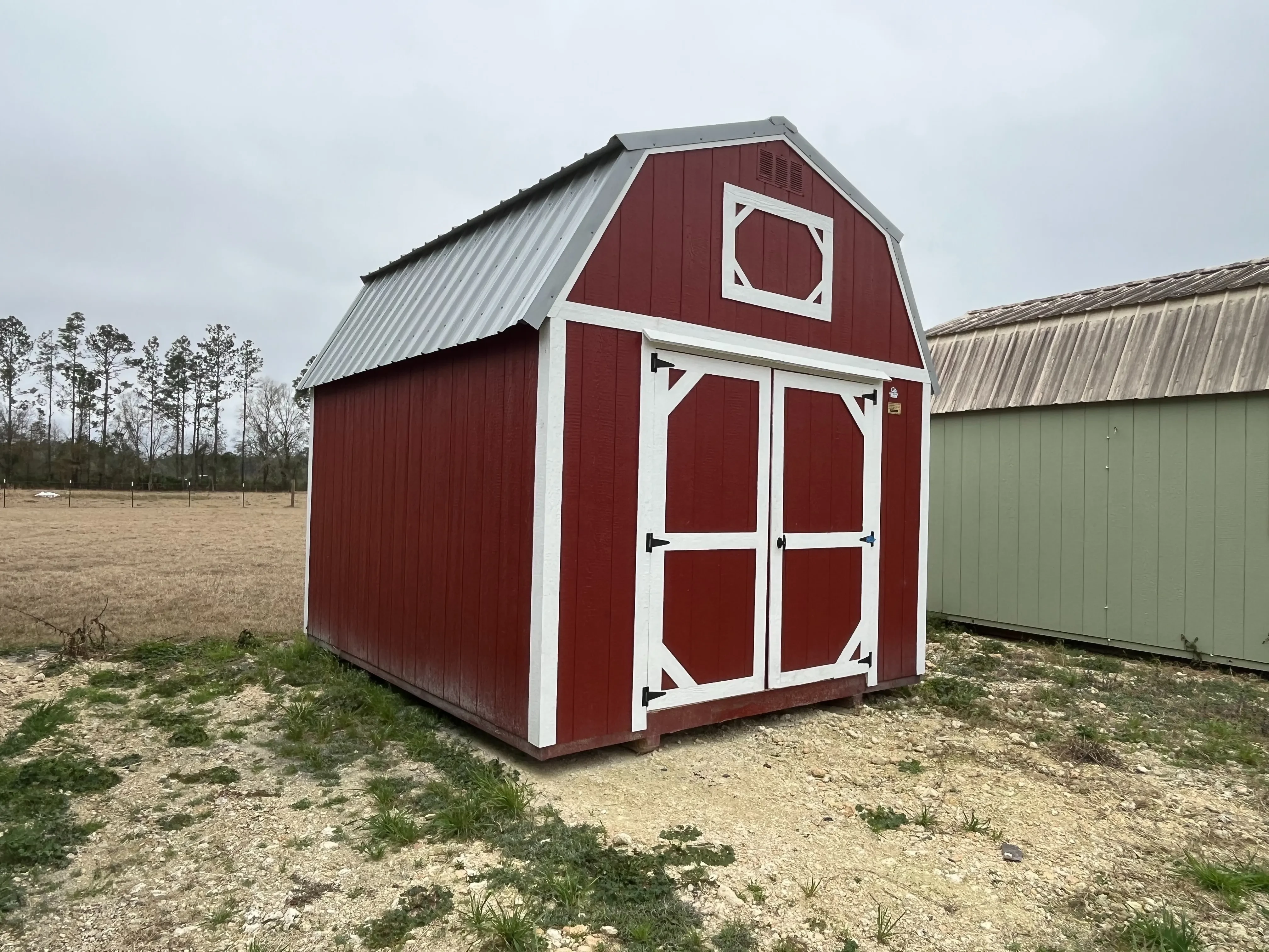 Exterior of a red 10x12 lofted barn economy with double wood doors