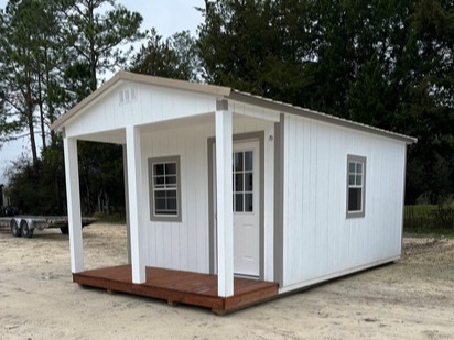 white cabin with a porch