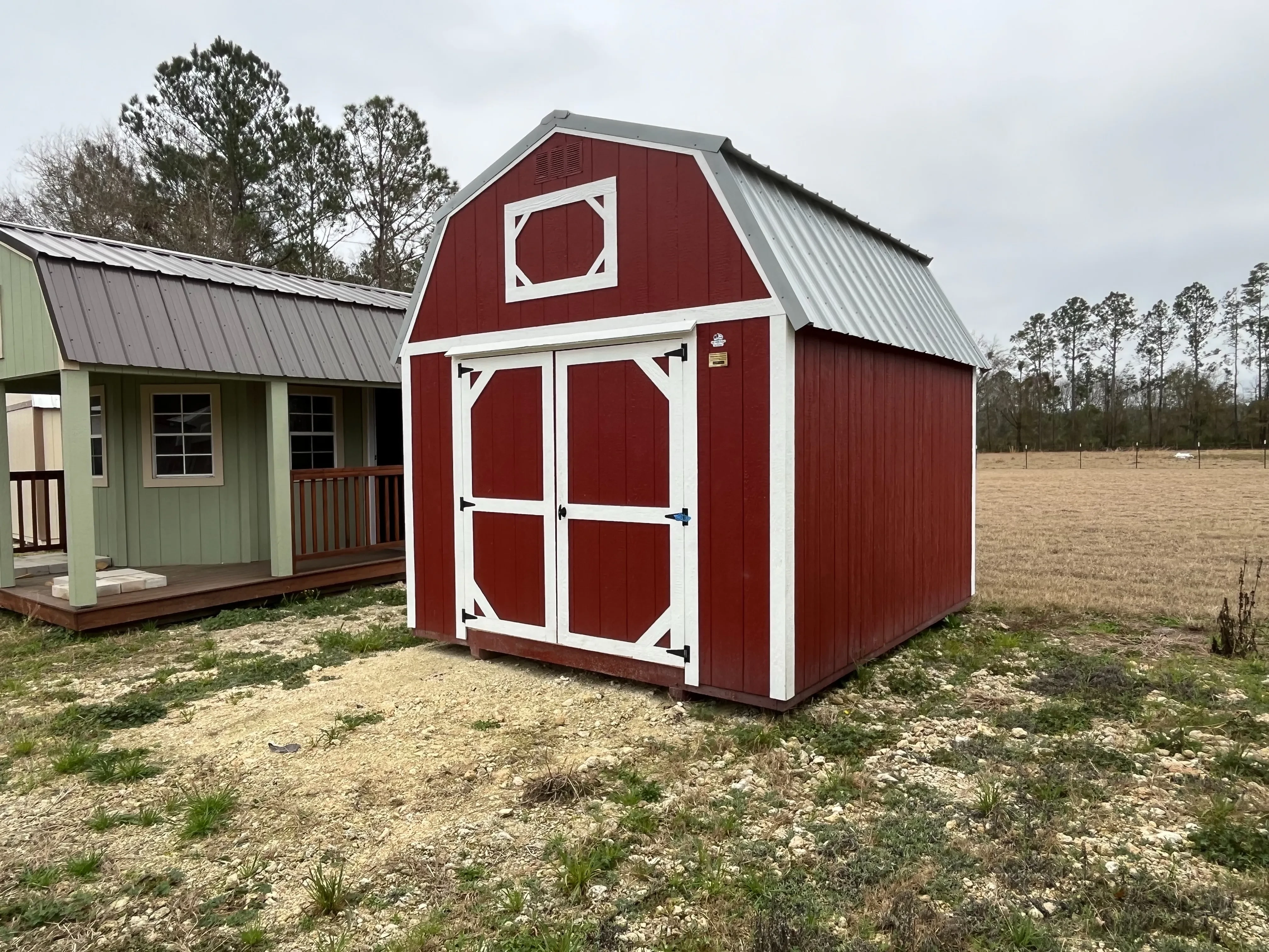 Exterior of a red 10x12 lofted barn economy with double wood doors