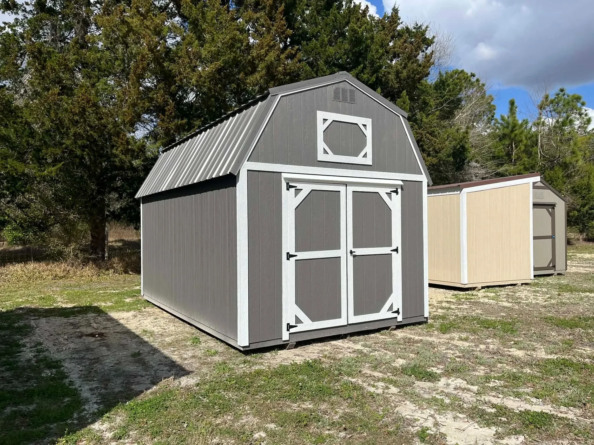 Exterior right side of a charcoal grey lofted barn with wood doors