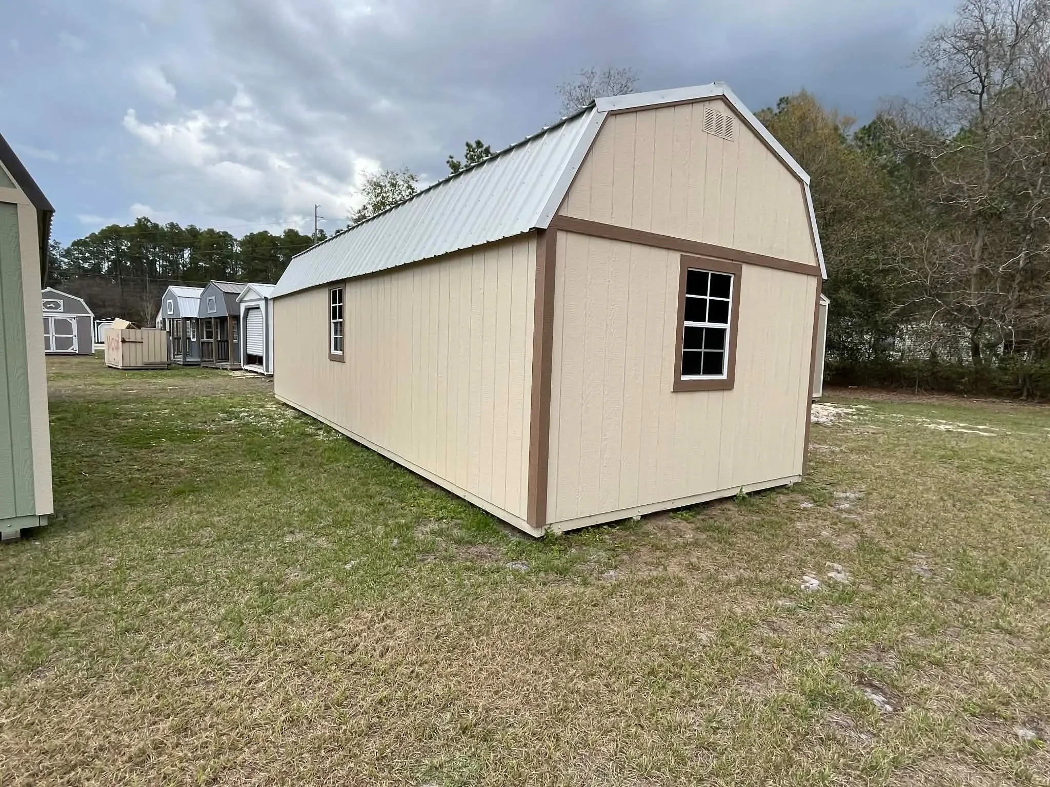 Exterior view of a 12x32 almond side lofted barn showing windows