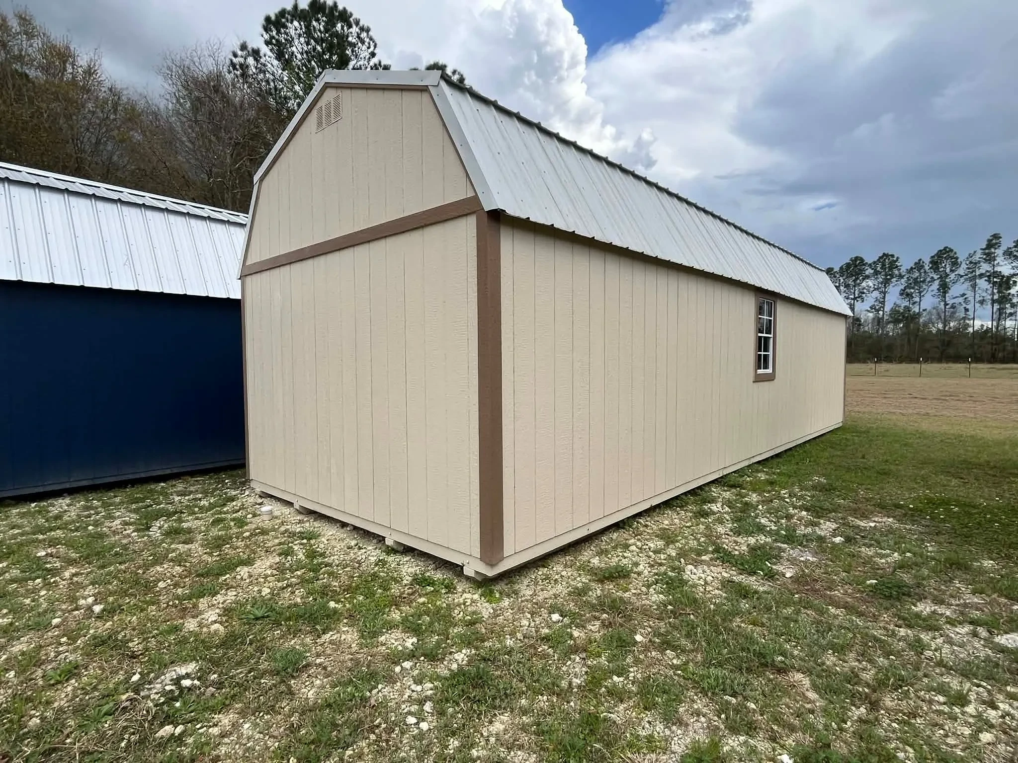 Exterior view of a 12x32 almond side lofted barn showing windows