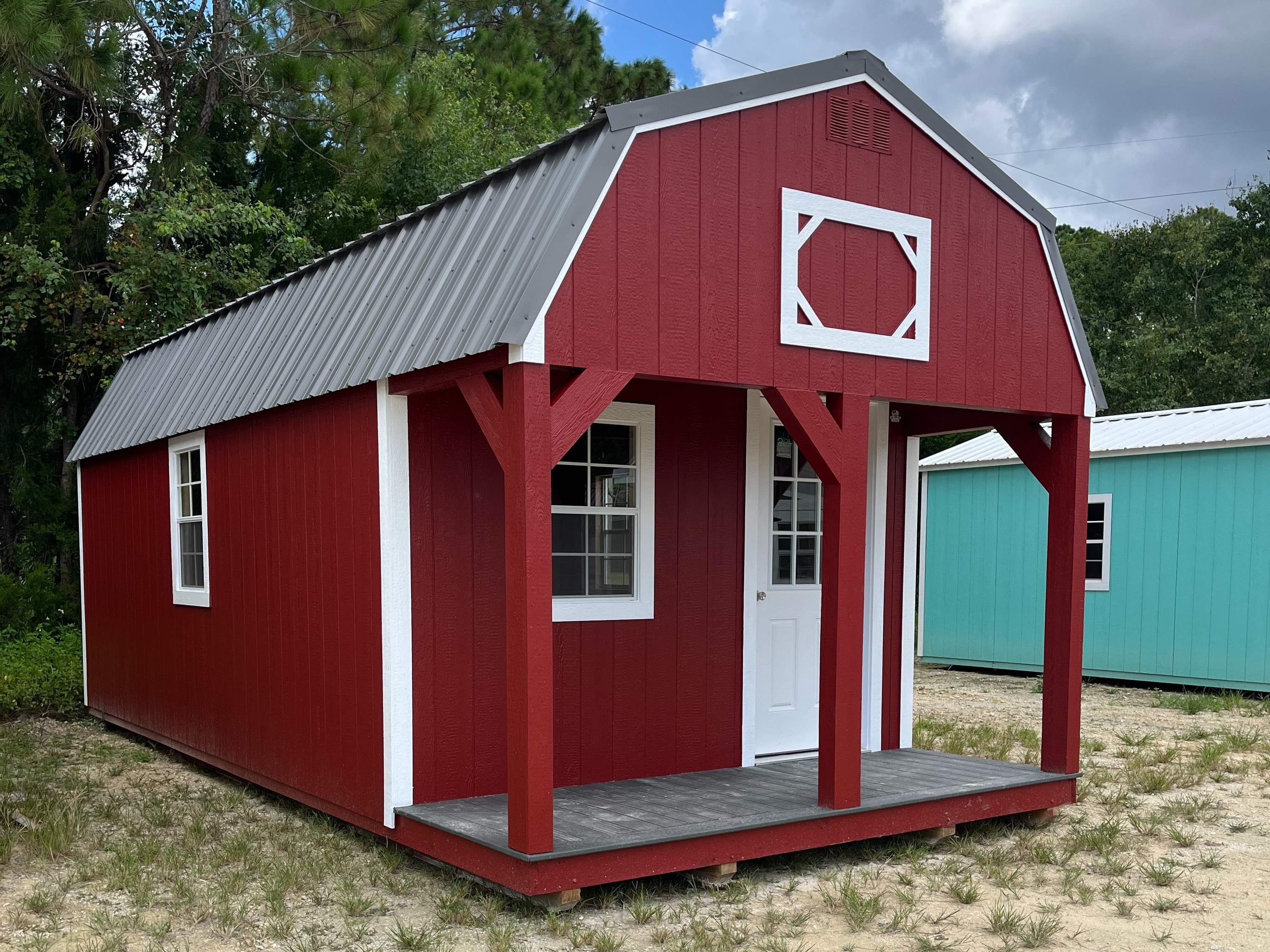 red and white lofted cabin with a porch