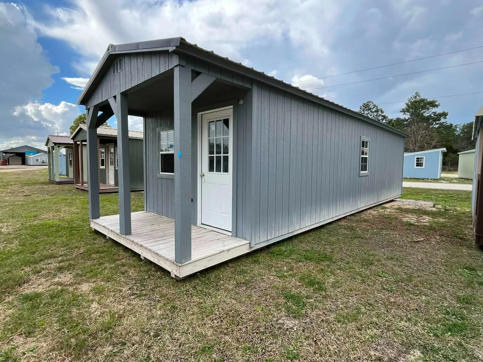 Exterior right front side of a dark grey 12x36 Cabin with a porch, entry door and windows