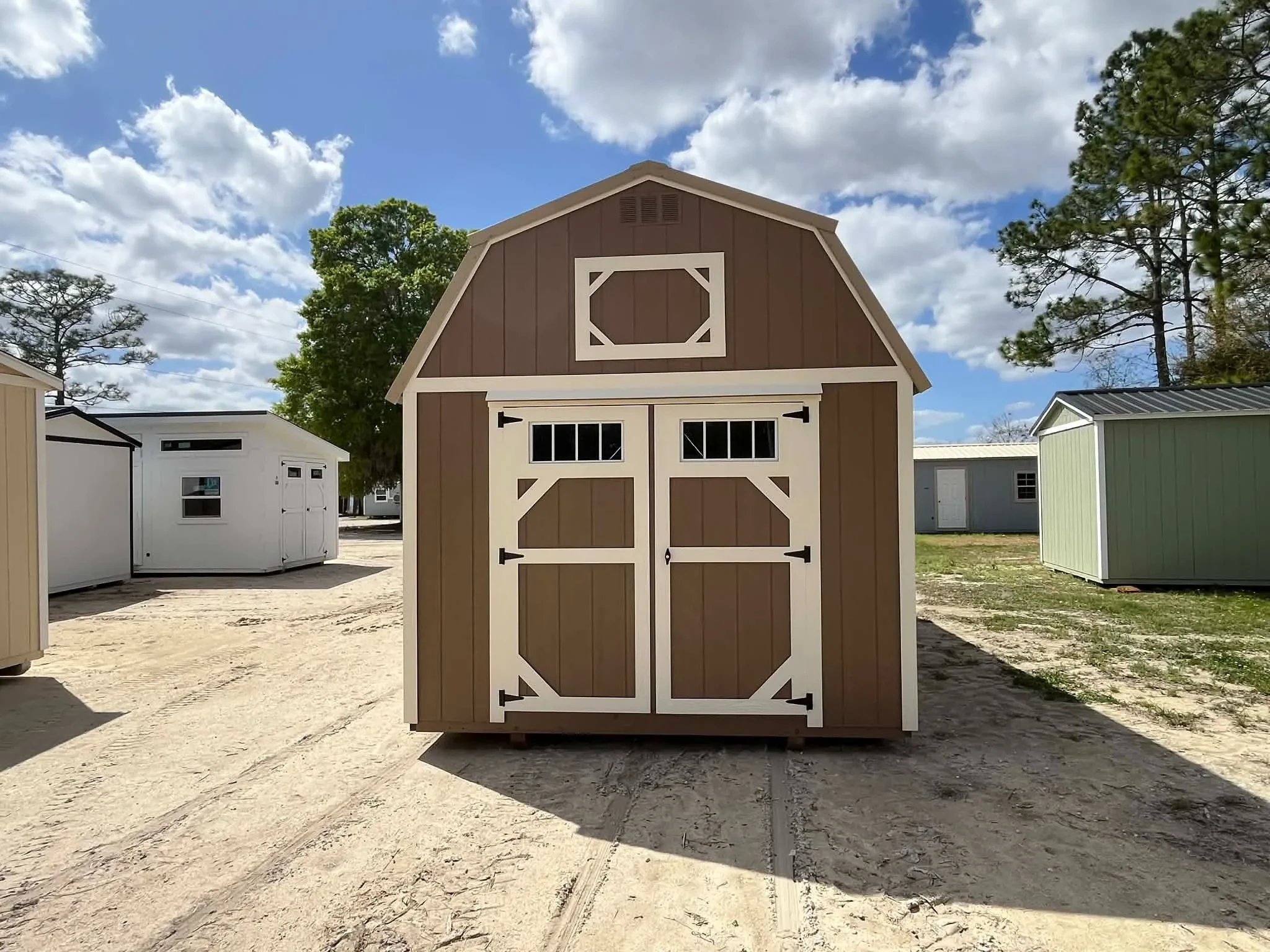 Exterior front view of a nuthatch color 10x20 lofted barn showing wood doors with transom window