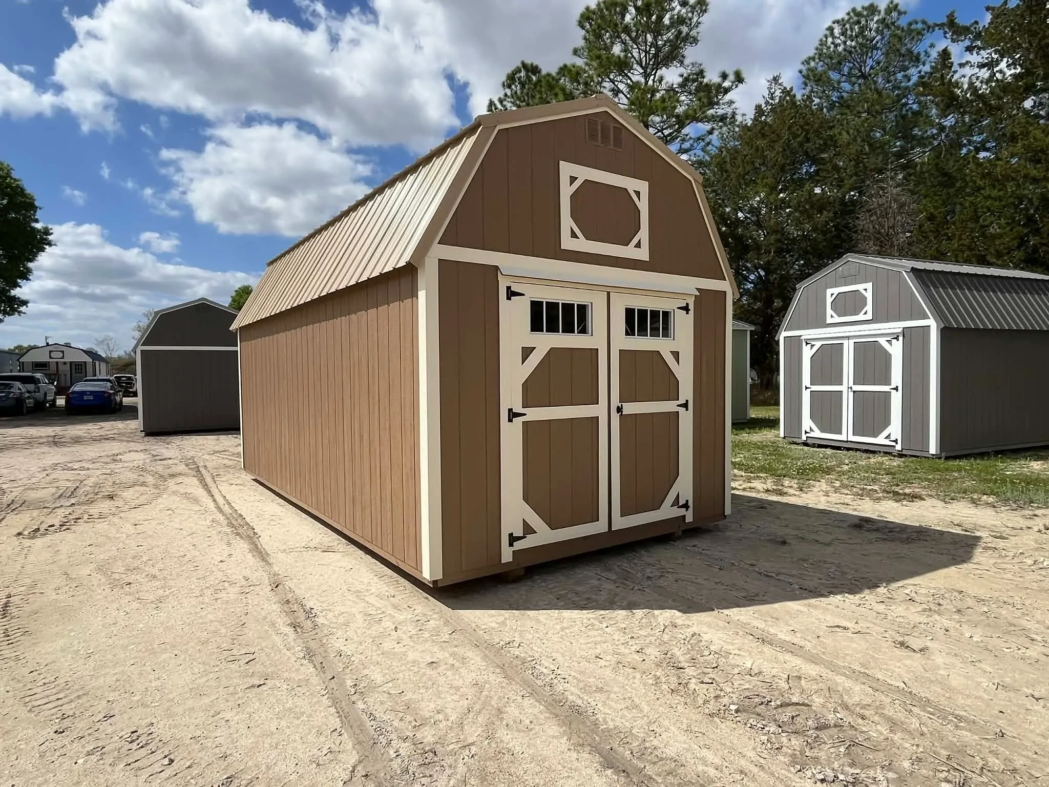 Exterior front side view of a nuthatch color 10x20 lofted barn showing wood doors with transom window
