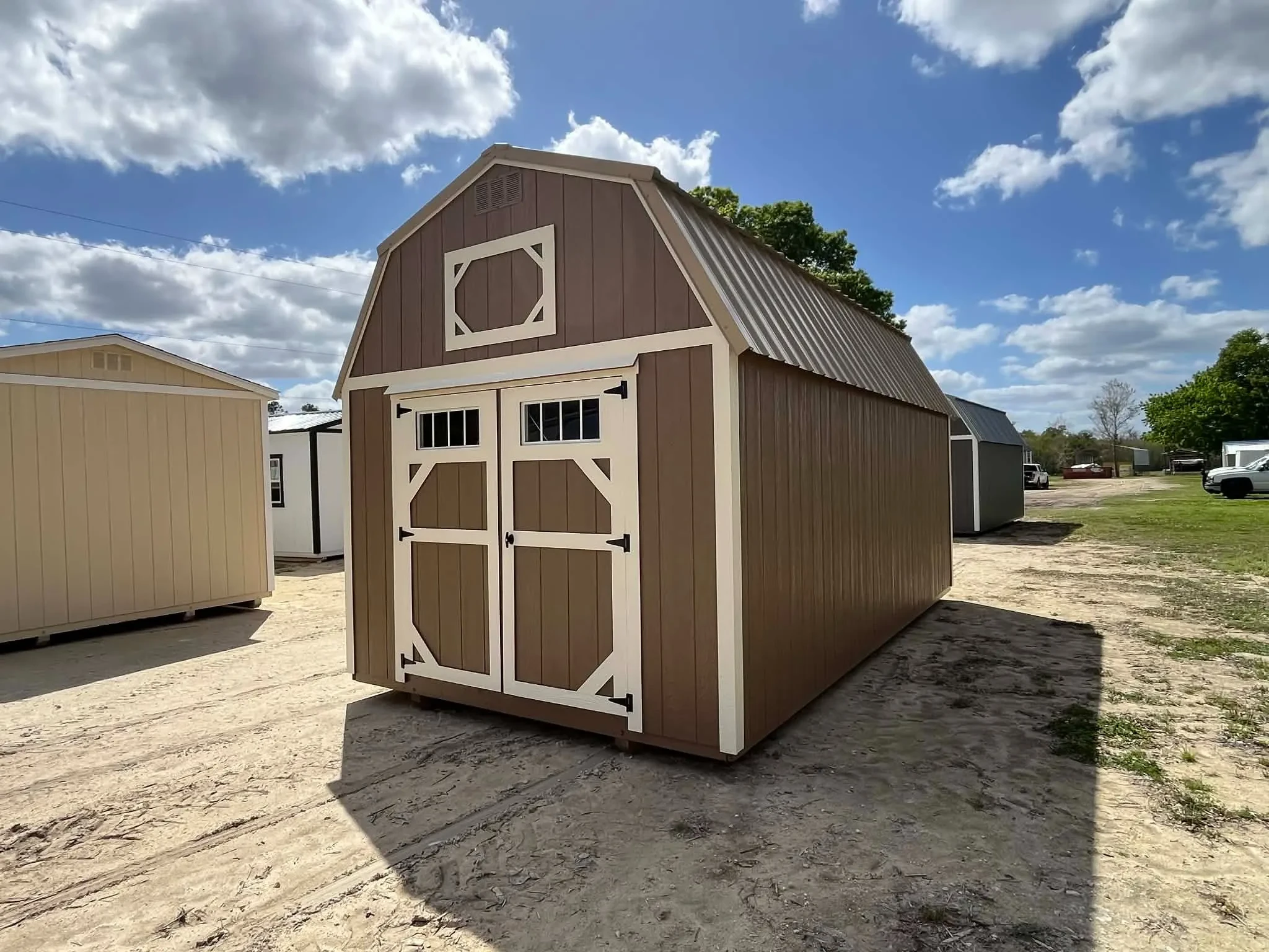Exterior front side view of a nuthatch color 10x20 lofted barn showing wood doors with transom window