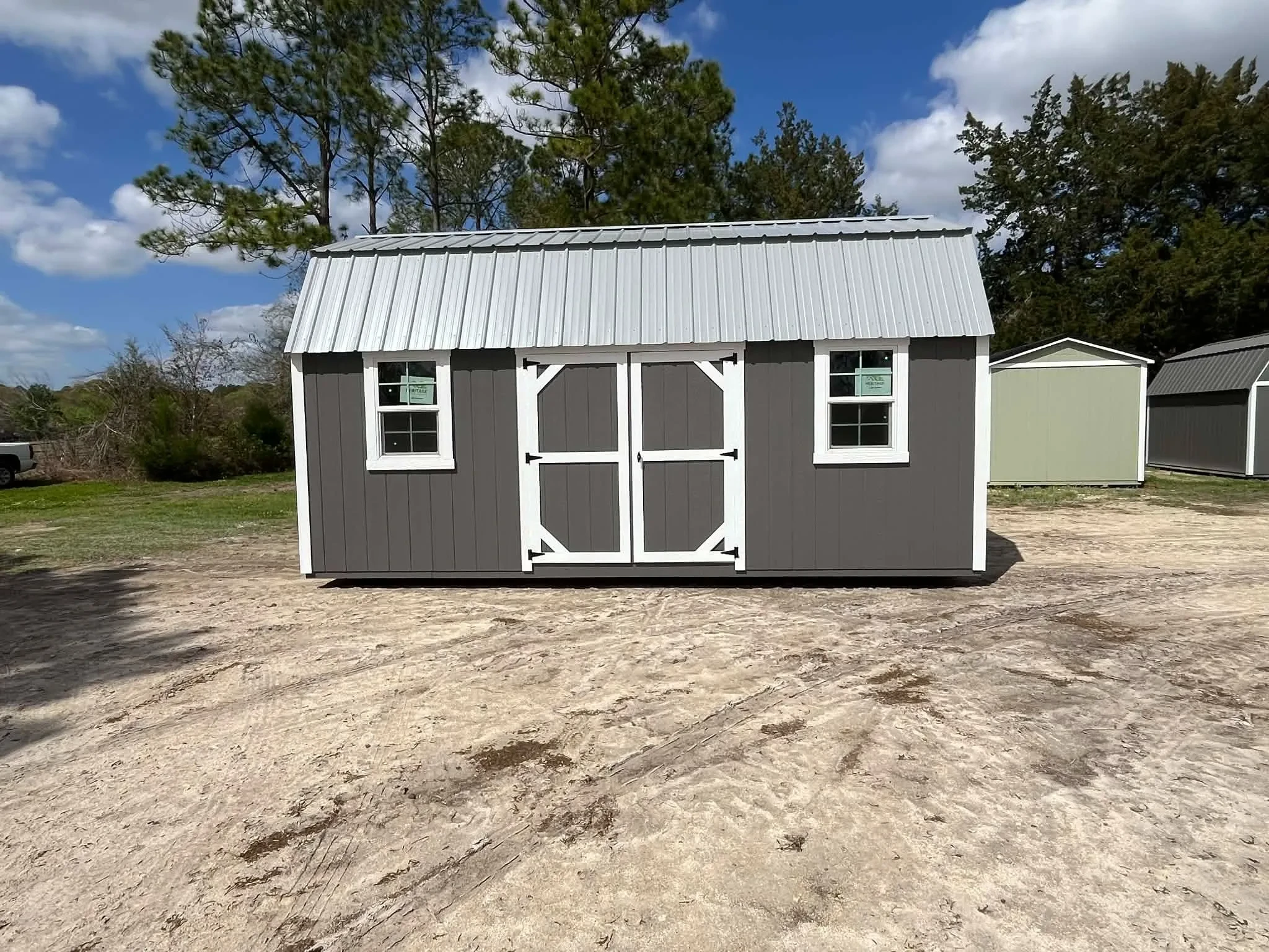 Exterior view of a dark grey 10x20 side lofted barn showing the doors and windows
