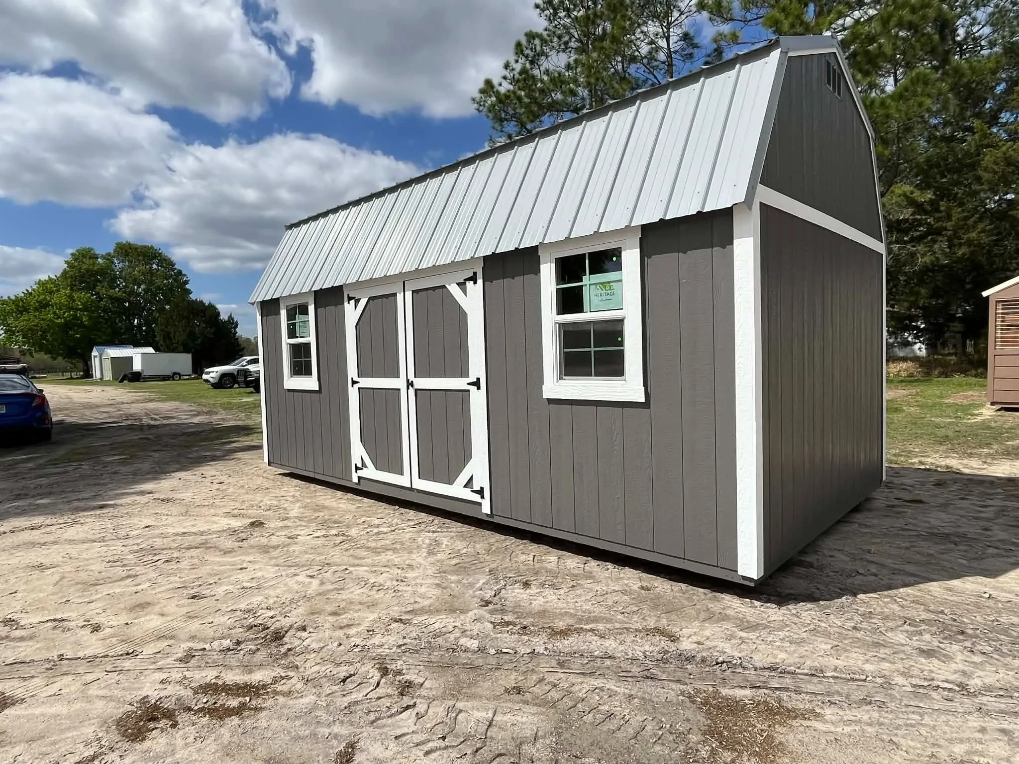 Exterior side view of a dark grey 10x20 side lofted barn showing the doors and windows