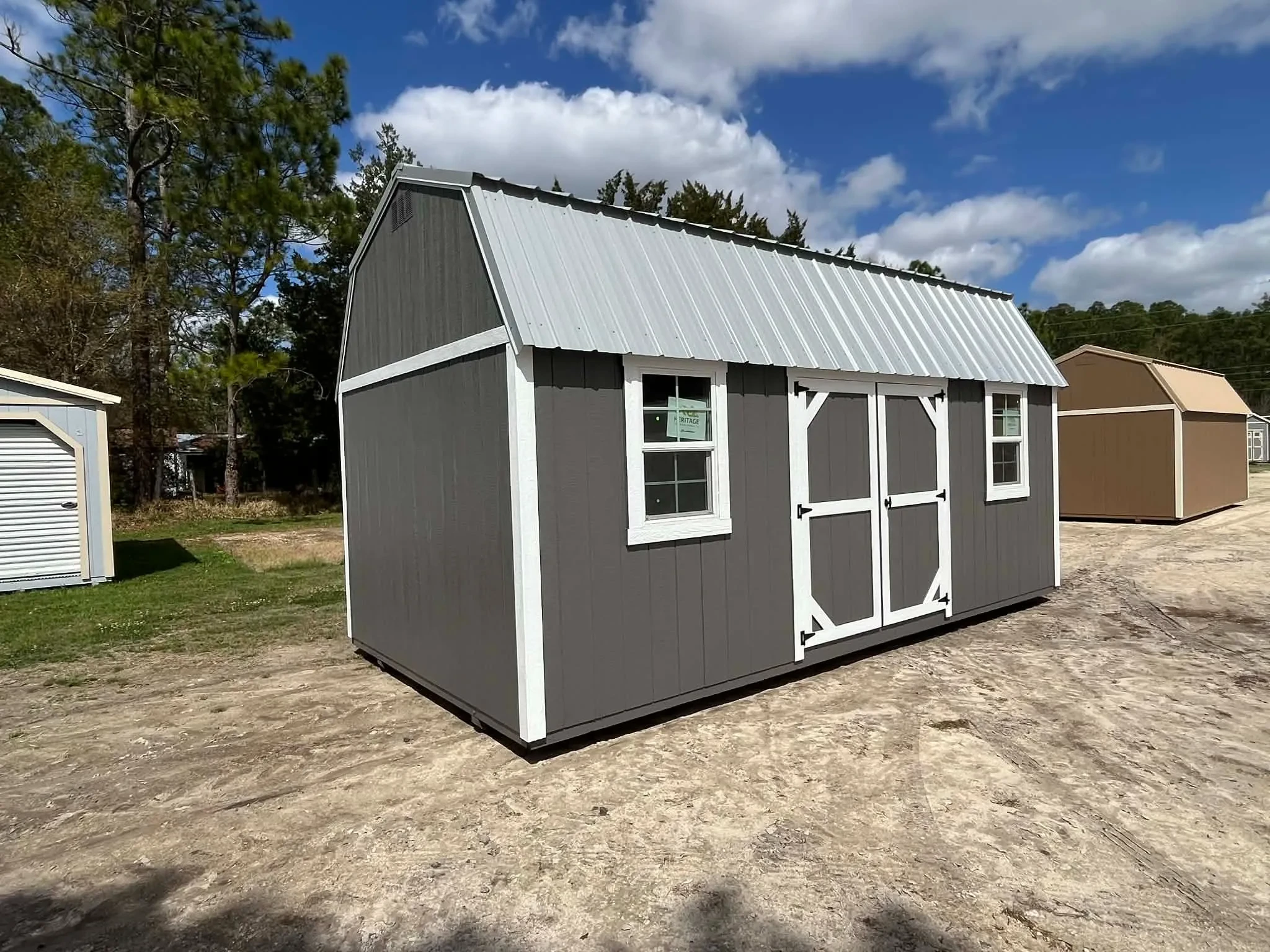 Exterior side view of a dark grey 10x20 side lofted barn showing the doors and windows